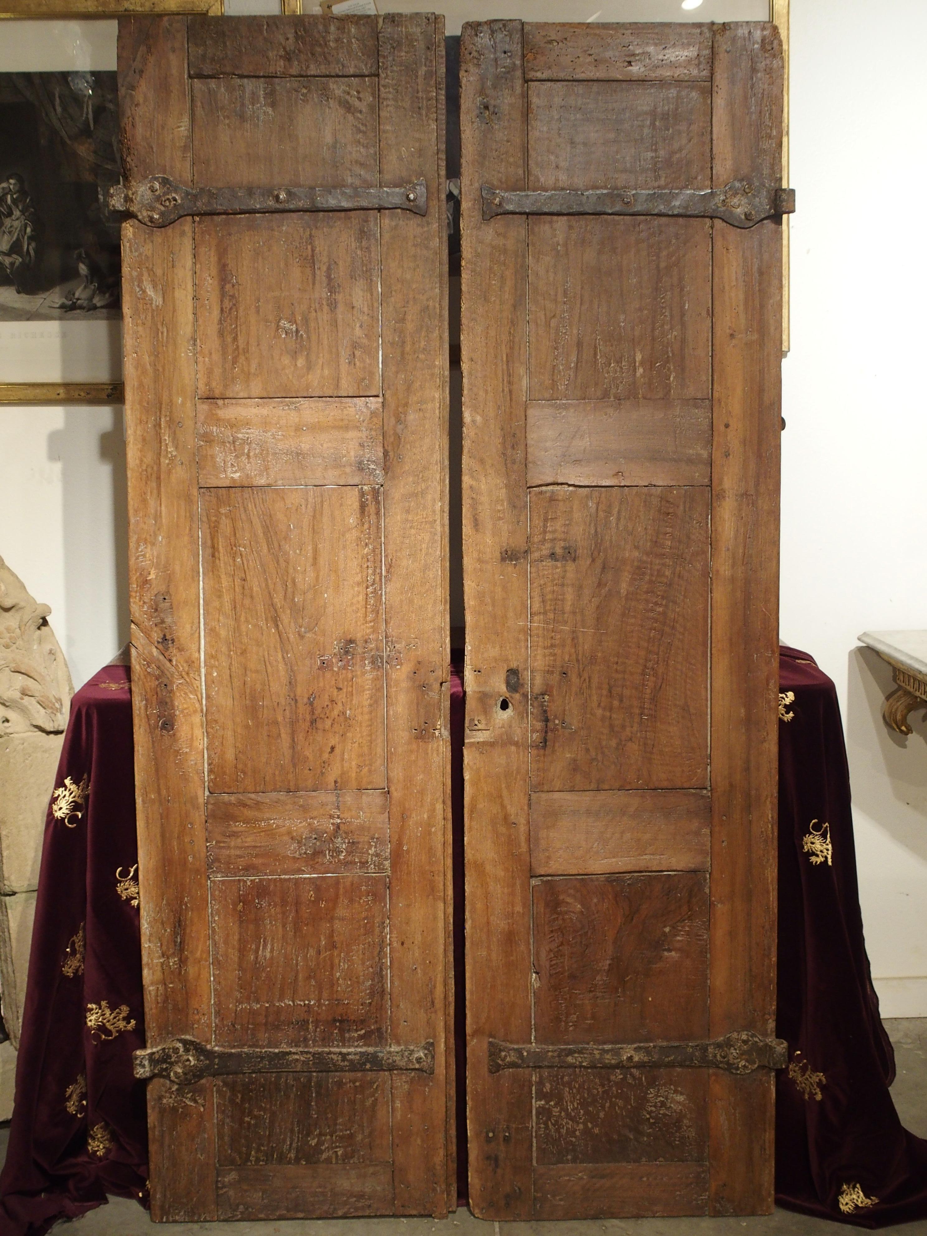 This is a pair of 18th century doors from Northern Italy, with large X-motif carvings and diamond shaped nailheads. They are carved out of an Italian Rovere wood, also known as durmast oak. The wood has a wonderful texture which has developed a warm
