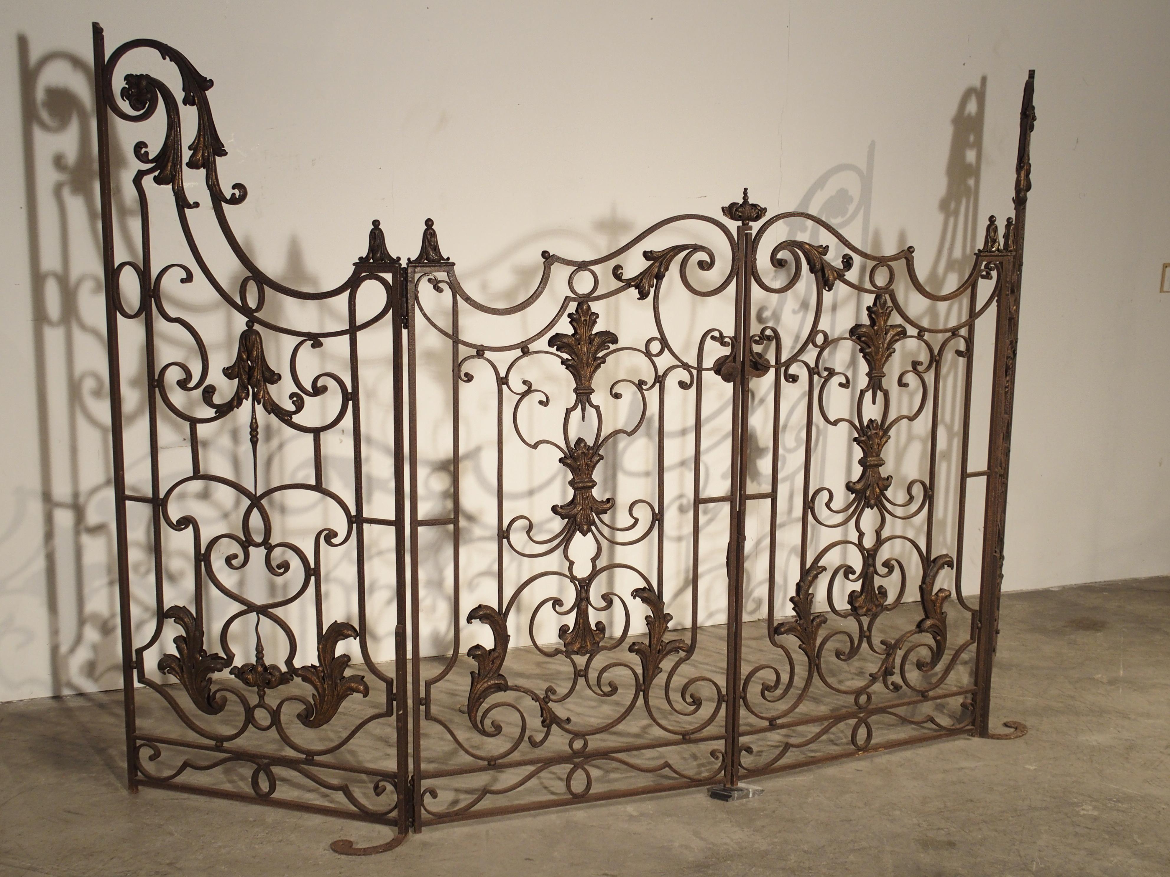 This fabulous 4 section wrought iron gate from France has beautiful scrolling motifs throughout, and it is in excellent overall condition. Some of the tole motifs have been modestly highlighted with gold lacquer. The rest of the iron gate has a worn