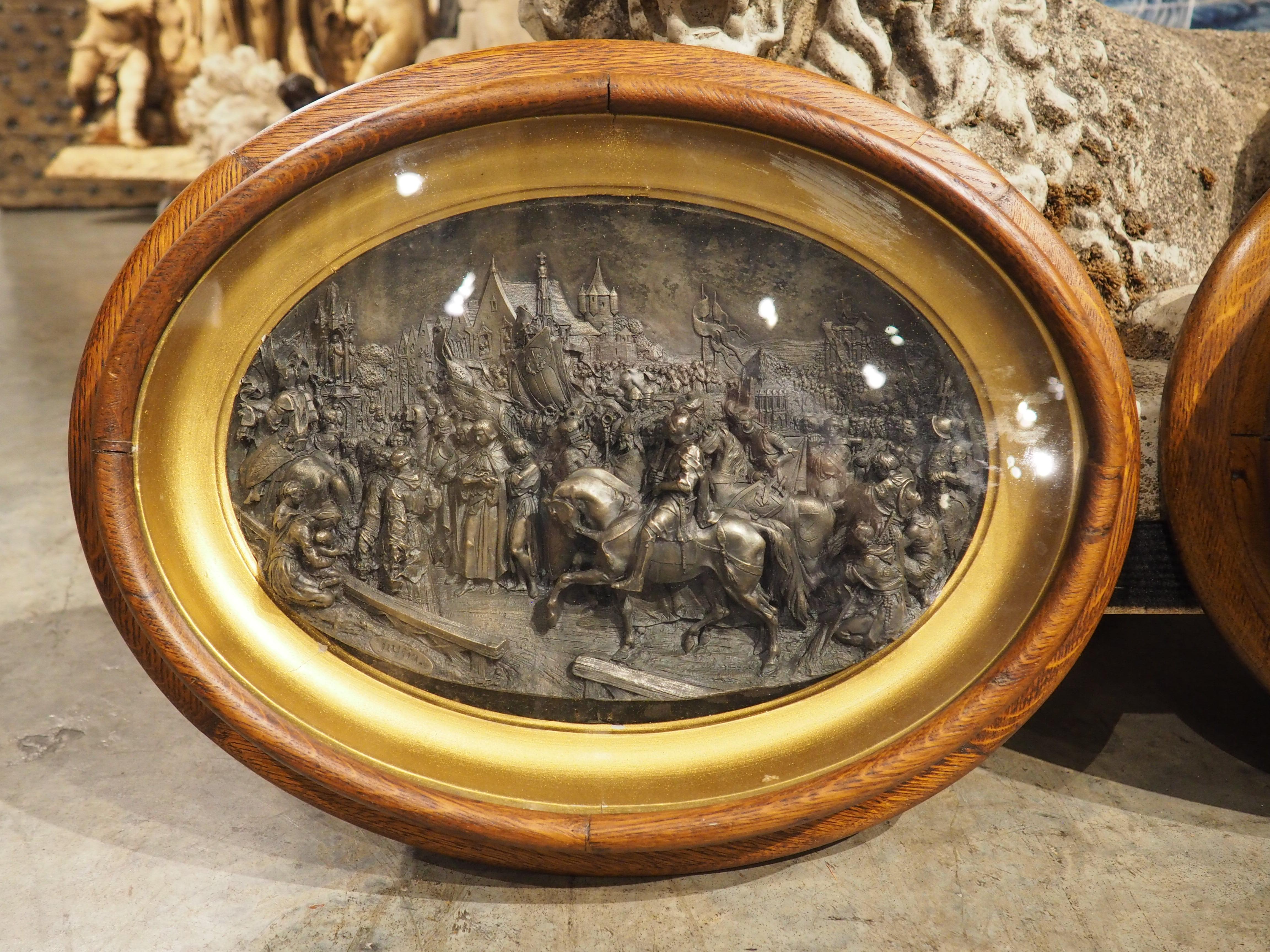 A pair of elliptical reliefs dating to circa 1850, these French plaques depict various stages in the life of St. Louis. The metallic reliefs, which are signed “Justin” in the lower left, are wonderful three-dimensional renderings surrounded by gold