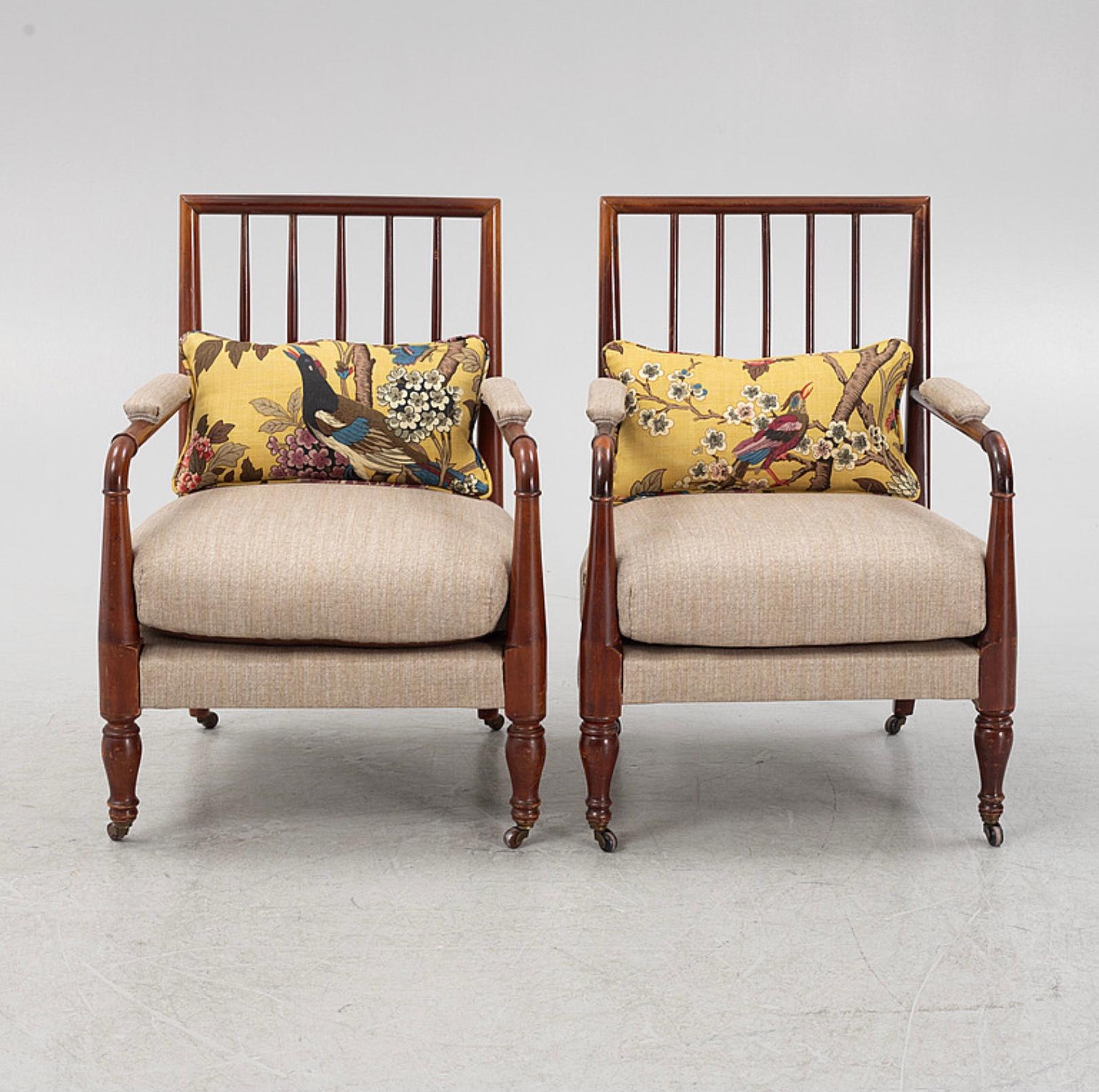 A lovely pair of Swedish spindle back open sided armchairs on turned legs with brass castors.
They are of neat proportions and upholstered in a neutral beige herringbone fabric with a fitted loose cushion seat.

These stylish chairs would work well