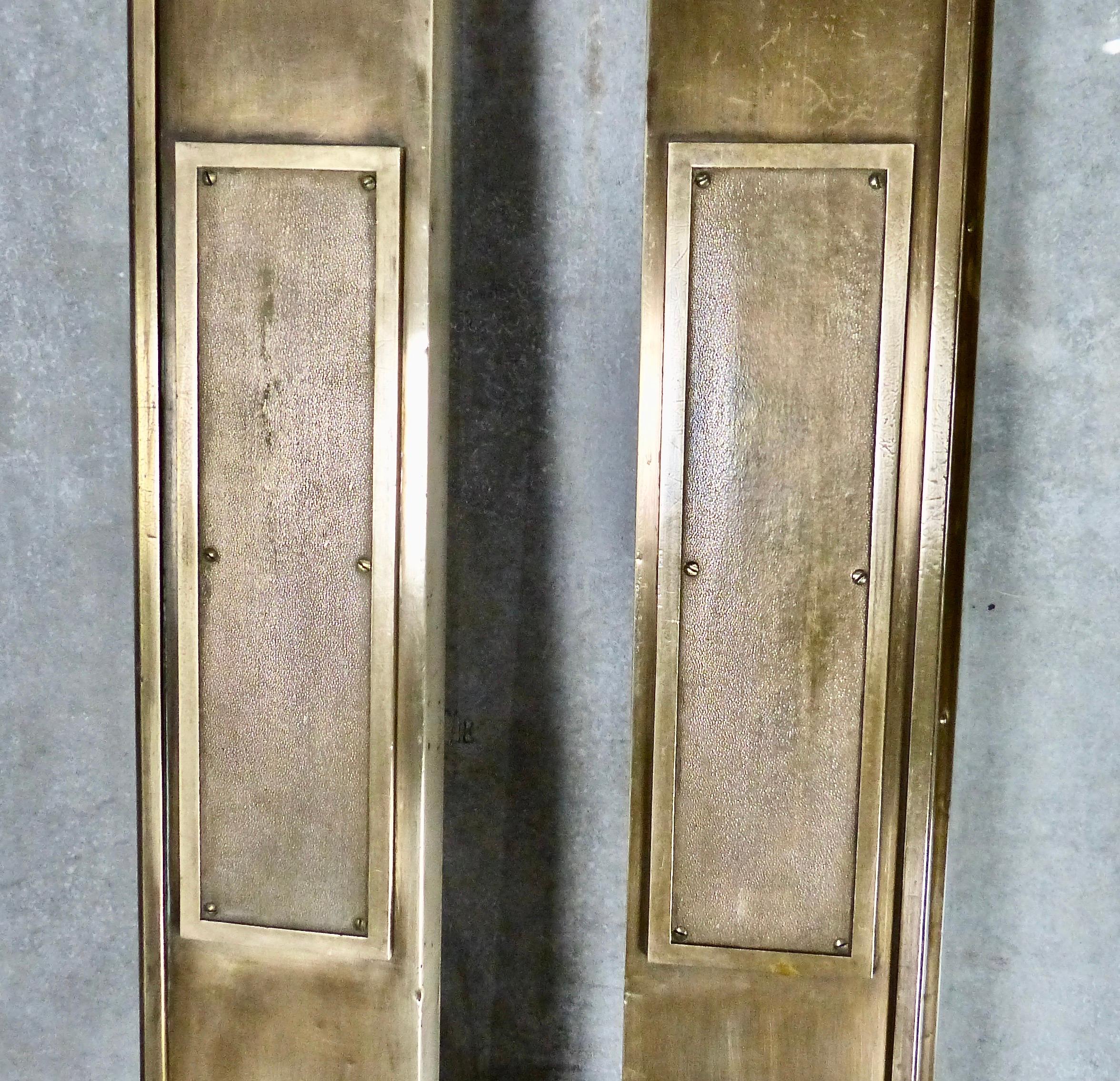 Matched pair of brass doors with glass panels and textured brass push plates. Clean, simple lines in a Classic brass door. We have four in stock salvaged from a building demolition decades ago. Price per door.
Dimensions: 83” H x 29.5” W x 2” D.