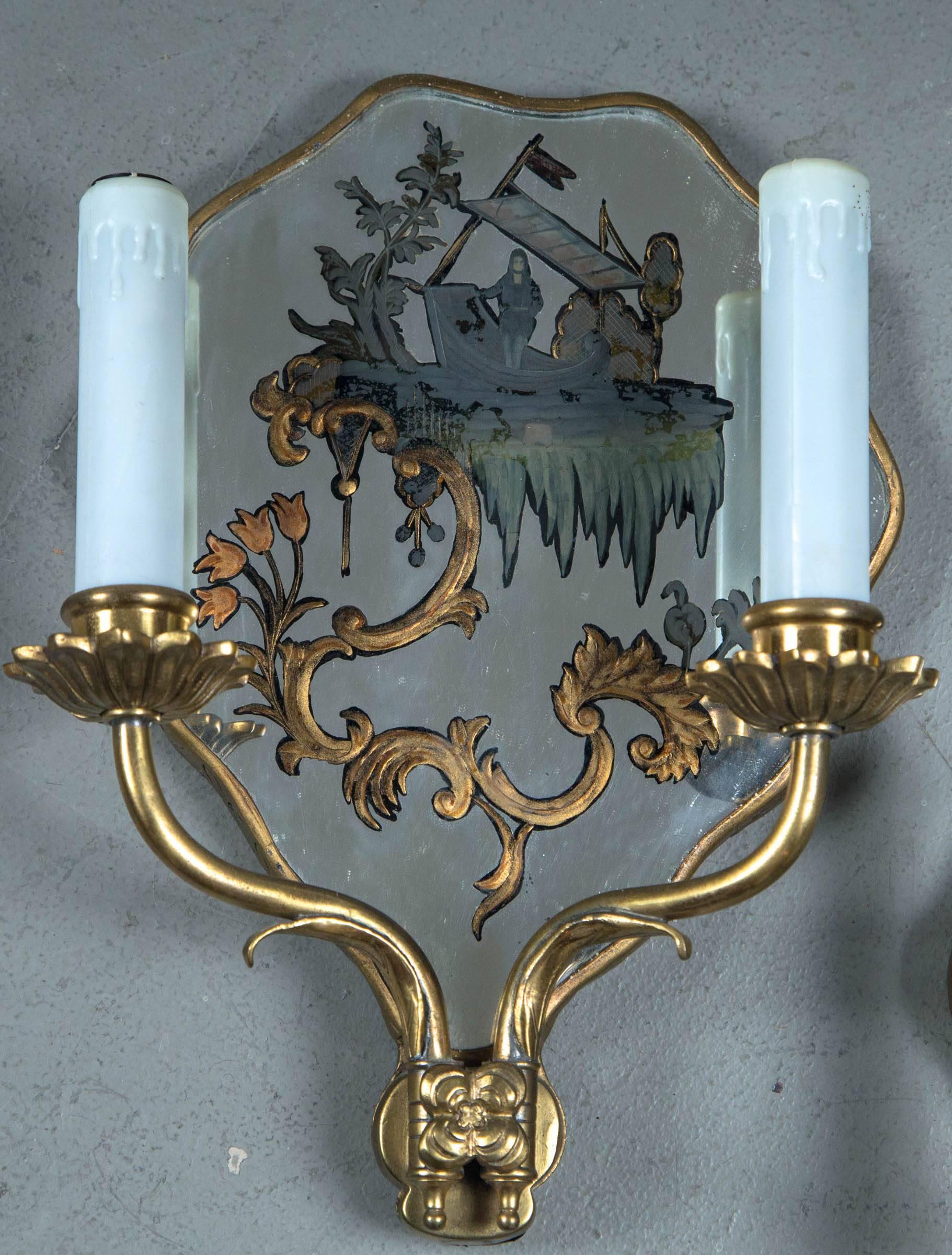 A pair of circa 1920 Caldwell hand-painted mirrored sconces.
