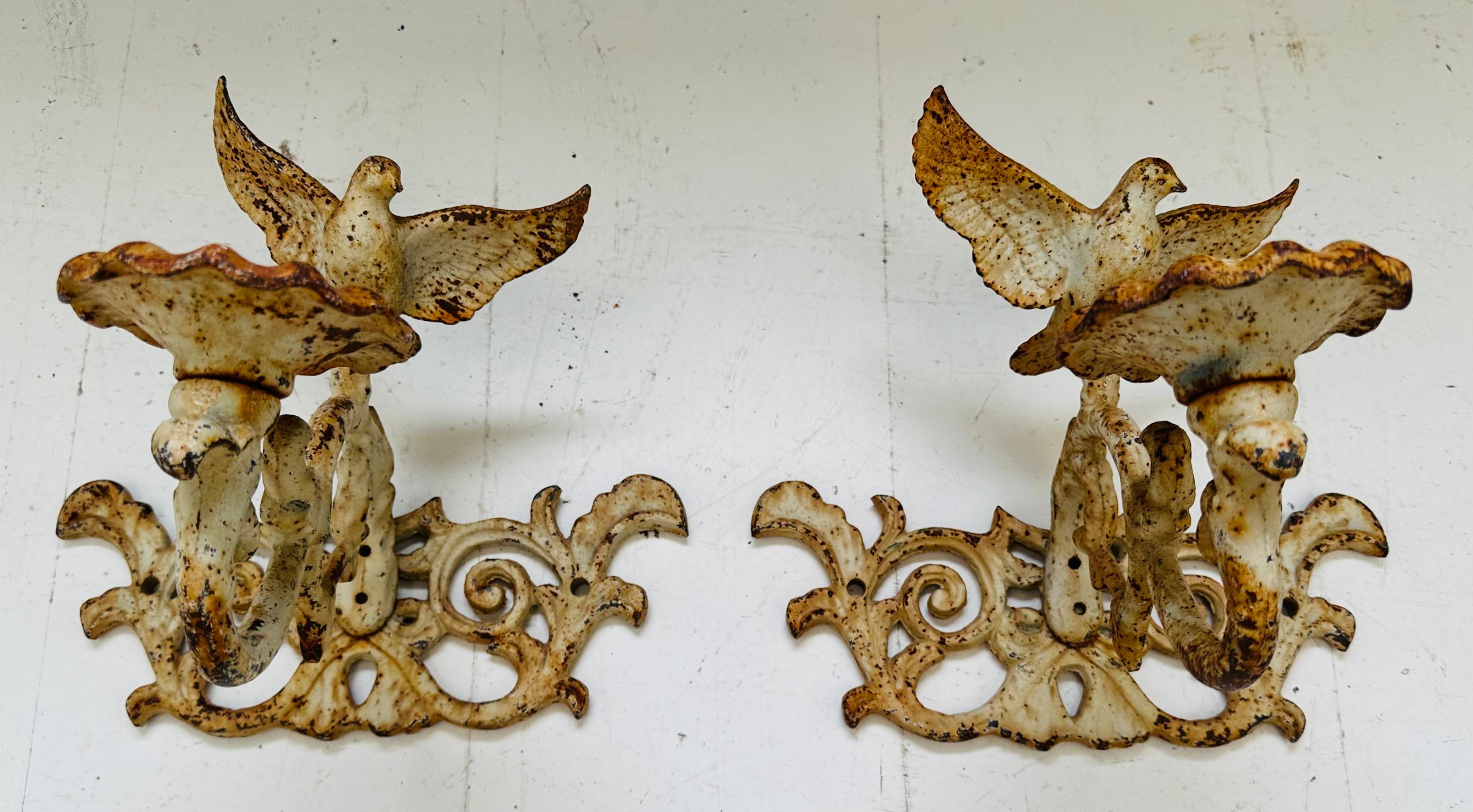 Pair of late nineteenth century/early twentieth century cast iron ornamental rustic garden candleholders.  Originated in Cuba around the 1890-1900 era. 

Each candleholder features an open-winged dove finial perched on top of a scrolled baroque cast