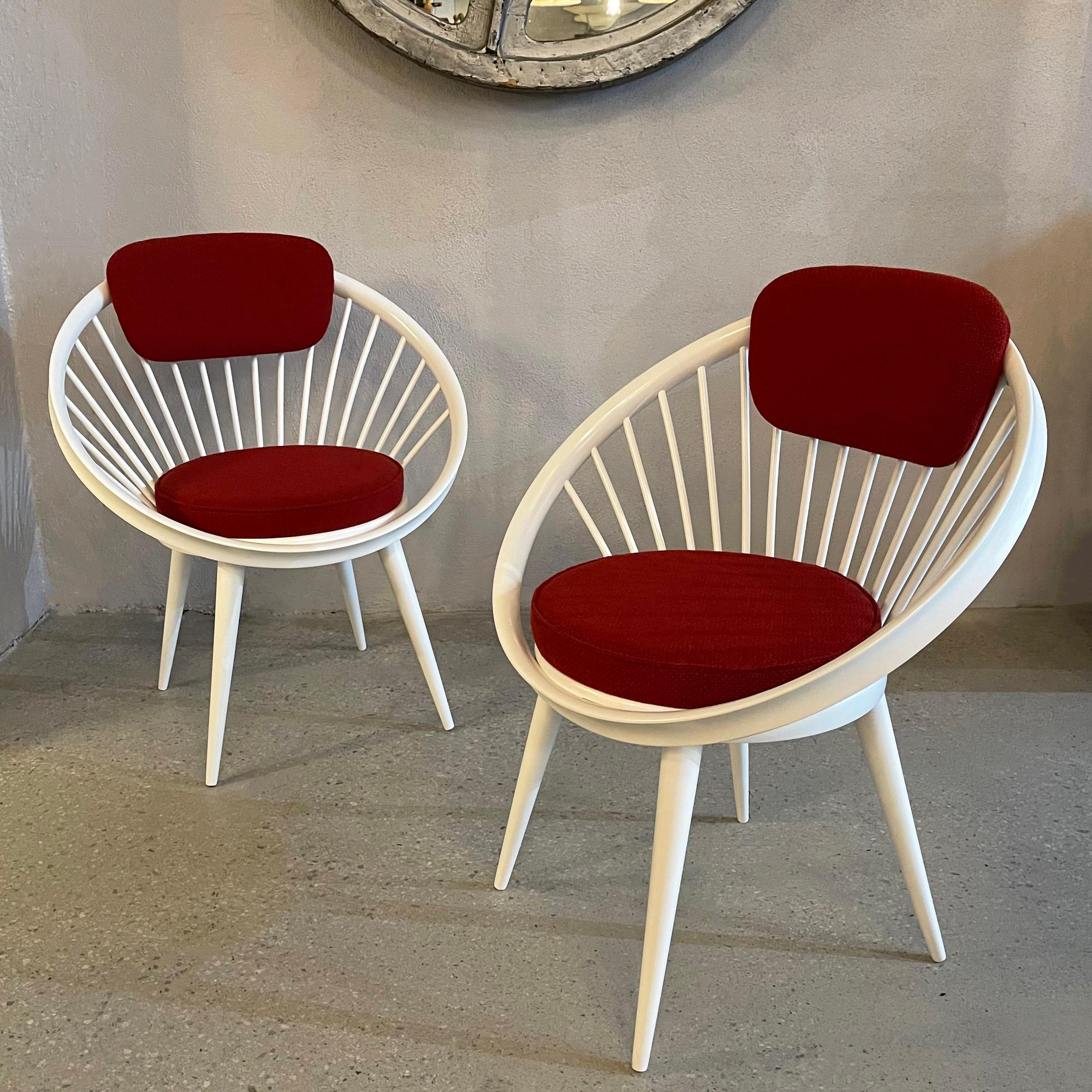 Pair of Scandinavian modern, circle lounge chairs by Yngve Ekström for Swedese, Sweden feature white lacquered, circular hoop, beech wood frames with spindle backs and upholstered seats and backrests in contrasting burgundy wool blend. The pair are