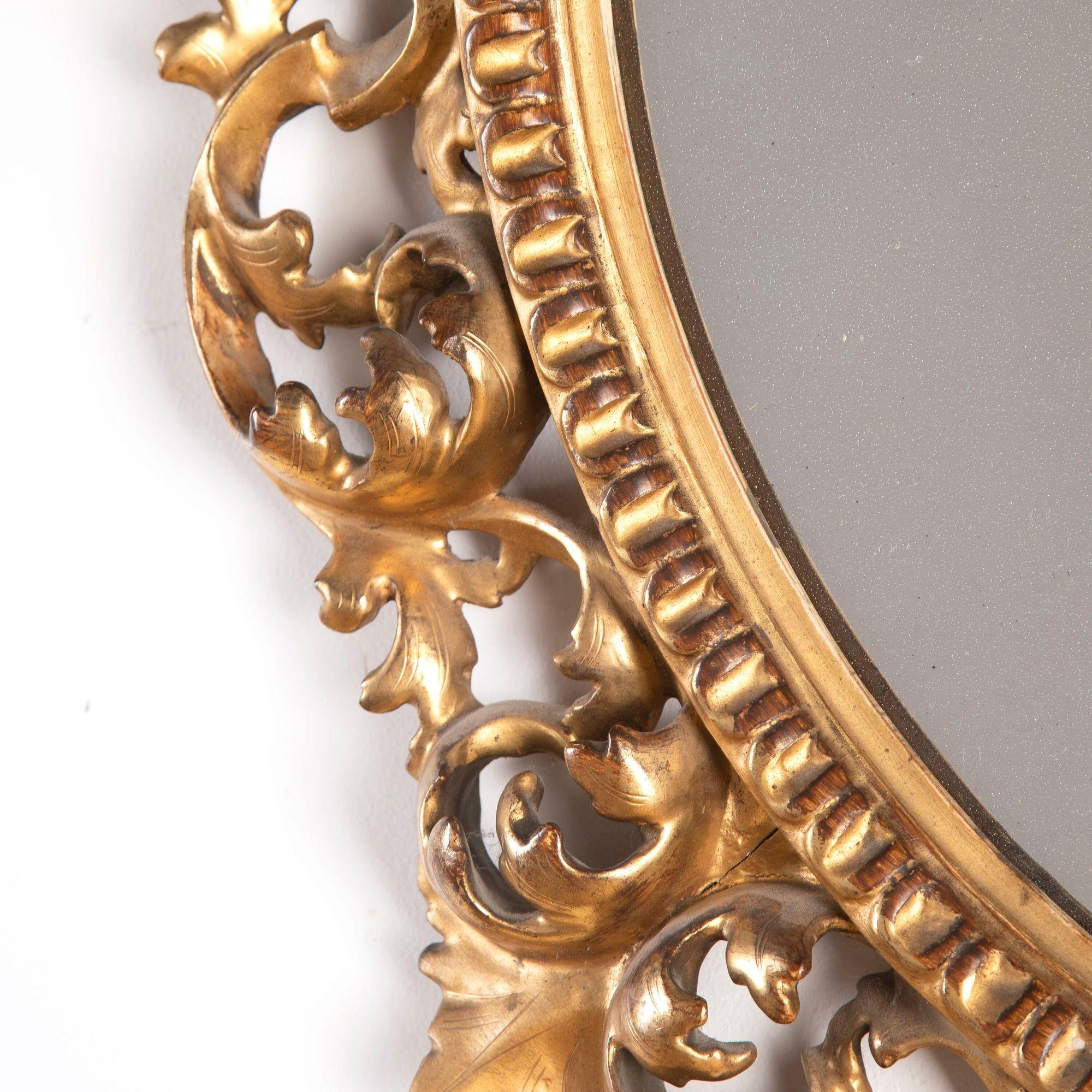 Exceptional pair of circular mirrors in late 19th century gilded and carved wooden Florentine frames.
These mirrors are of superb quality and still retain the maker's label of this most prestigious, leading supplier of furniture to the English