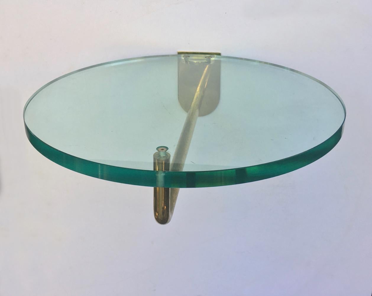 A pair of circular glass and brass shelves, for display or storage, second half of the 20th century, unsigned.

The shelves were found in Europe, and were perhaps used for shop display, as both have an aged patina and signs of use including