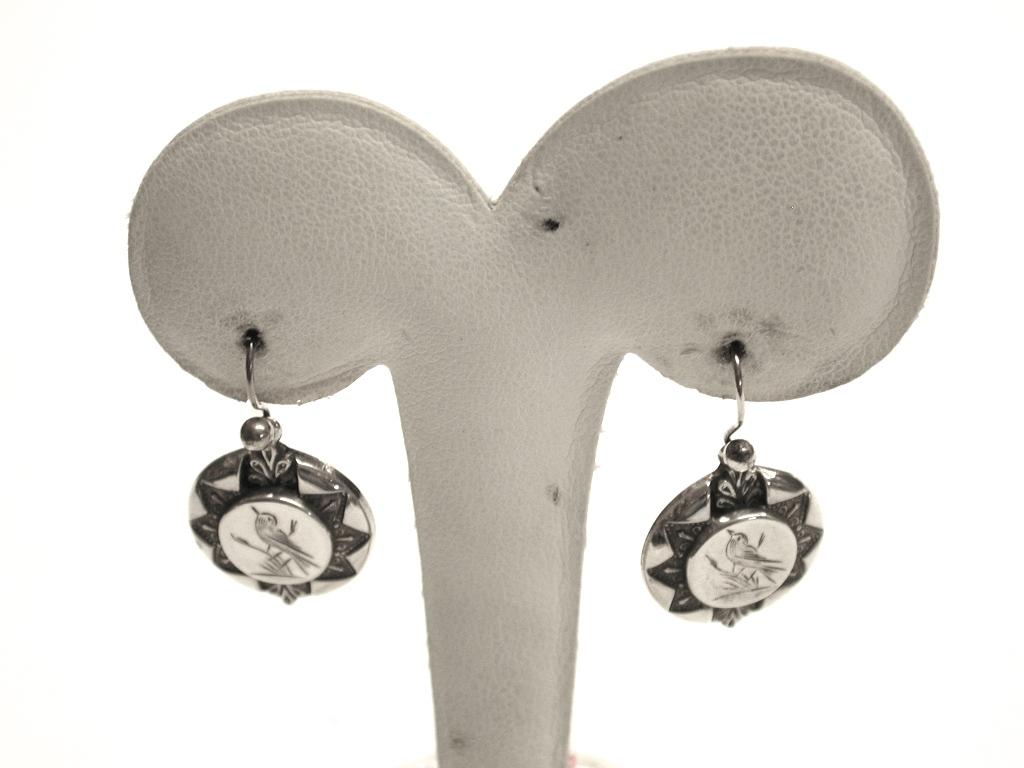 Pair of pretty silver earrings, assayed in Birmingham, dated circa 1880.
Nice engraving of a bird on each one with etruscian decoration around the outside.
 