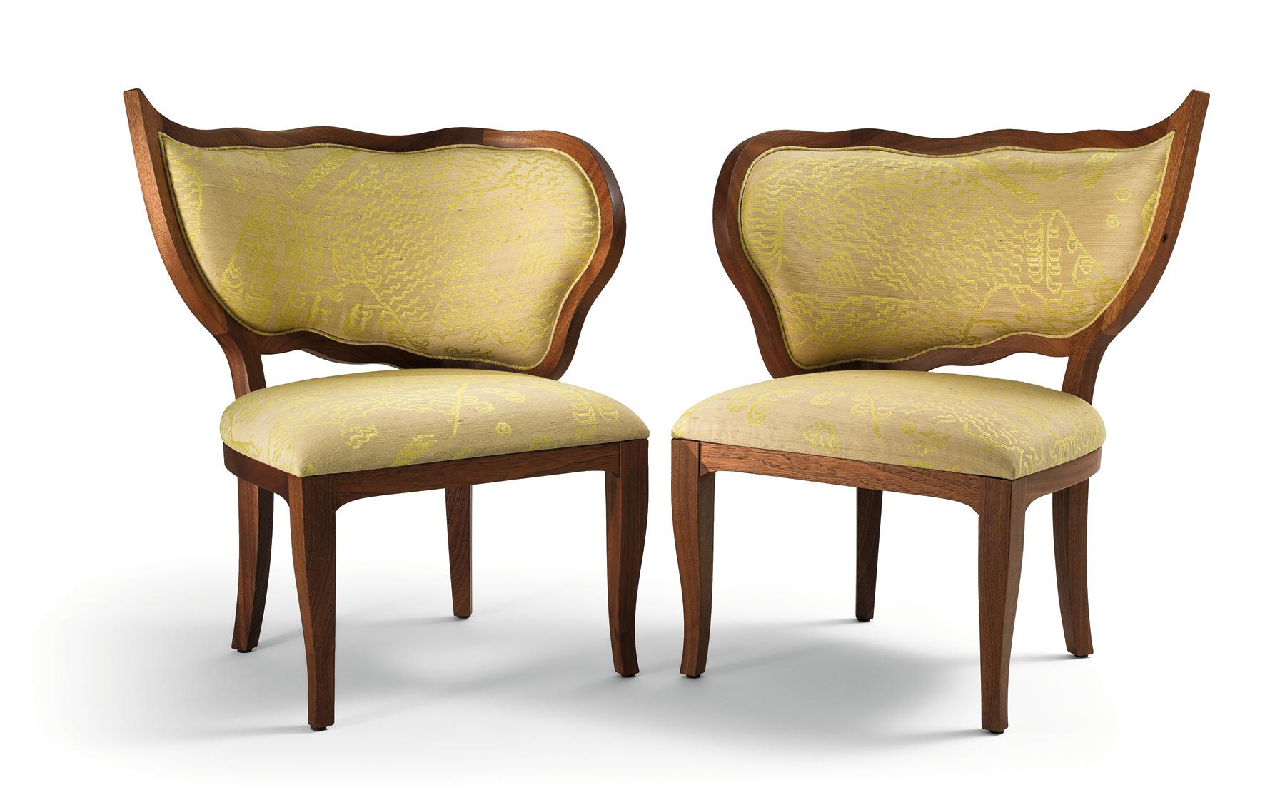 Este exquisito par de sillas presenta una delicada onda suave en el respaldo y patas sutilmente arqueadas, creando una armonía estética que rezuma elegancia. Elaborada con precisión, la estructura está hecha de caoba maciza con un acabado de caoba