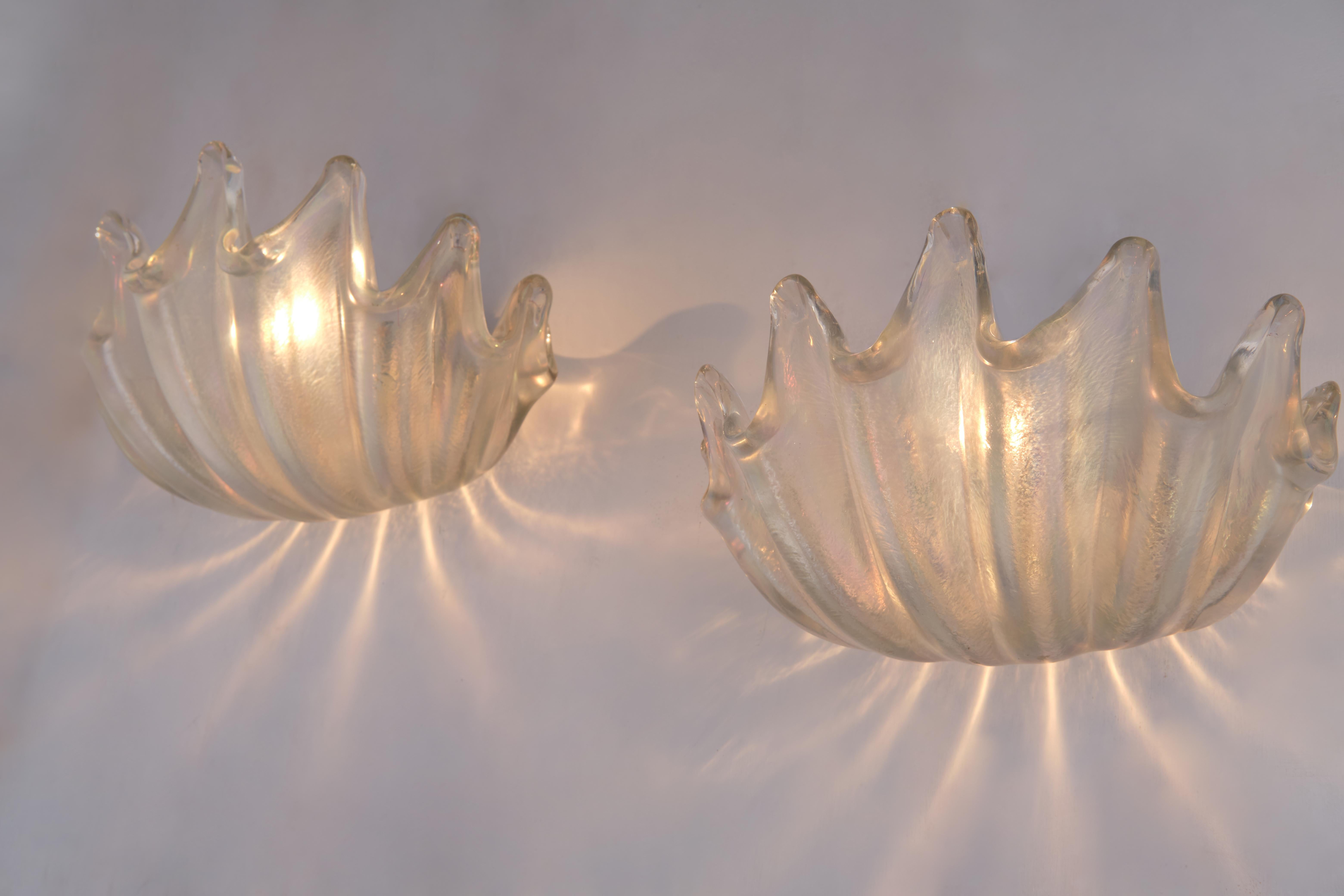 This rare pair of clamshell sconces by Ercole Barovier for Barovier & Toso are a true masterpiece, with its heavy transparent iridescent glass, deep ribbing and pronounced lobes, Italy, circa 1940. These unique hand blown crystal wall lights are