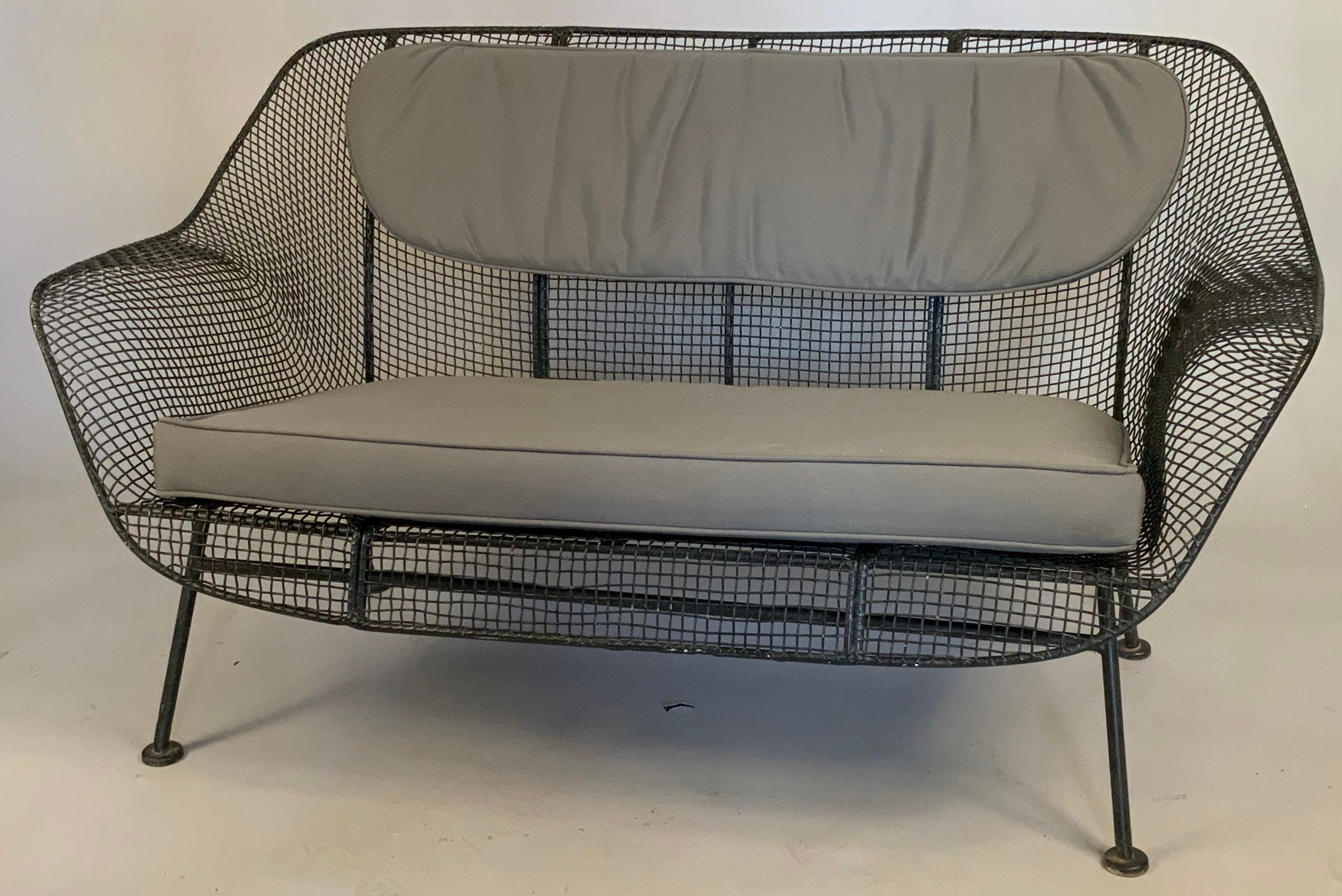 A pair of 1950s wrought iron and steel mesh settees from Russell Woodard's iconic Sculptura series. Beautiful and Classic sculptural design, finished in black, but can be finished in any color you choose. Cushions not included but can be custom