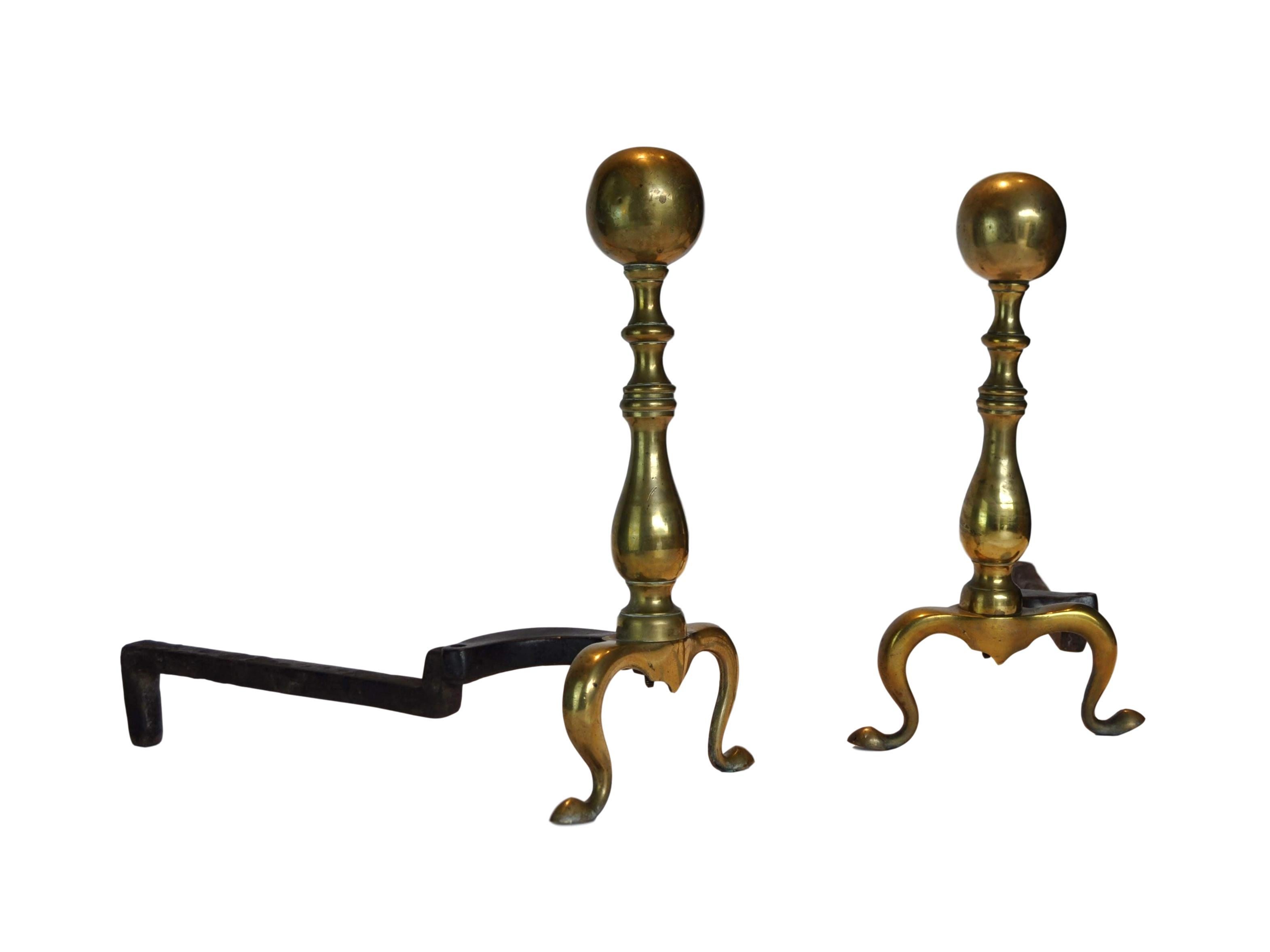 Classical pair of early 20th century brass cannonball andirons. Very versatile to fit any space.
