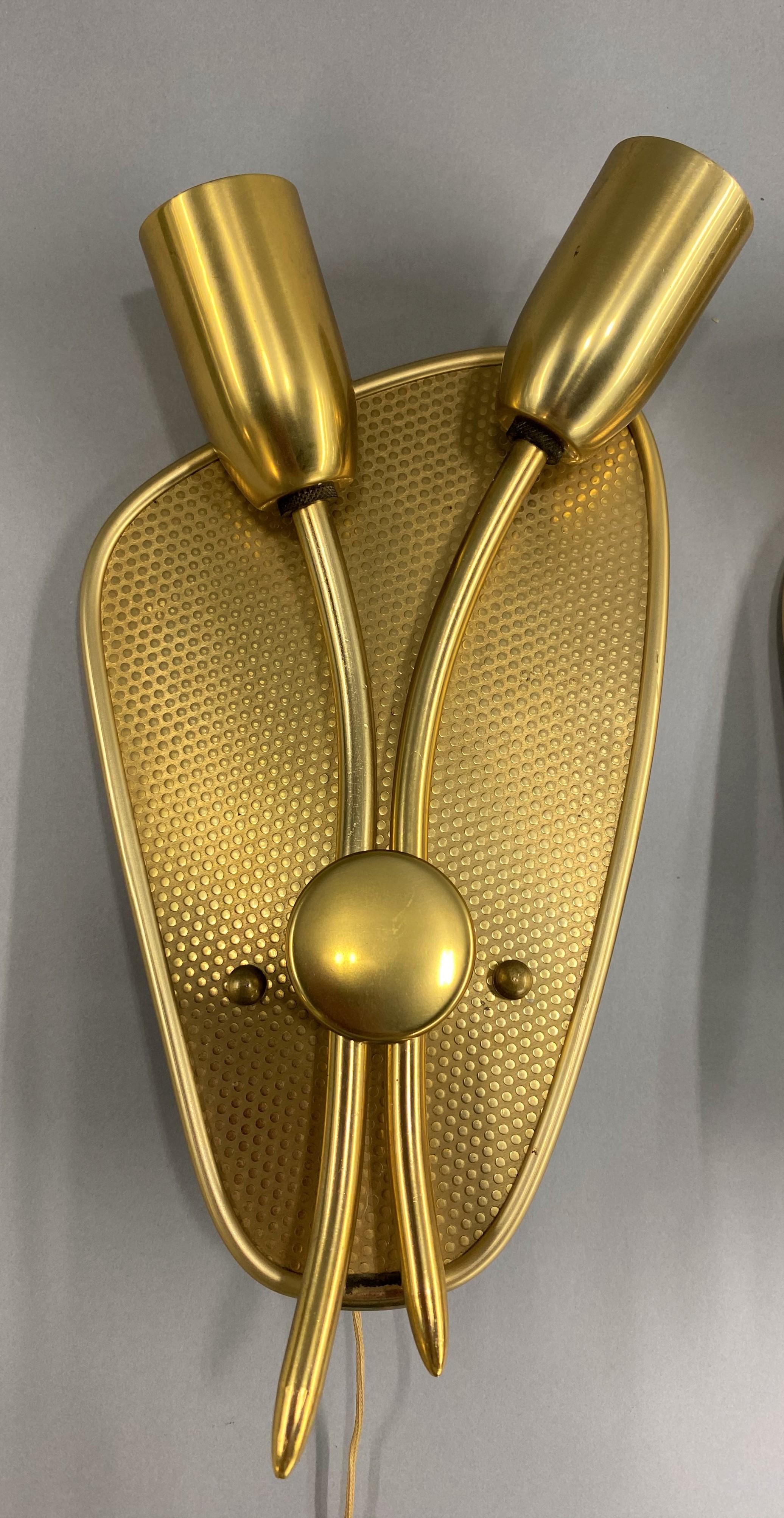 A wonderful pair of Classic Mid-Century Modern gilt metal tulip form two-light sconces, original pulls, in pristine condition, new old stock, with only a few minor surface imperfections, circa 1950s. Dimensions: 14.5 in H (including pull) x 5.5 in W