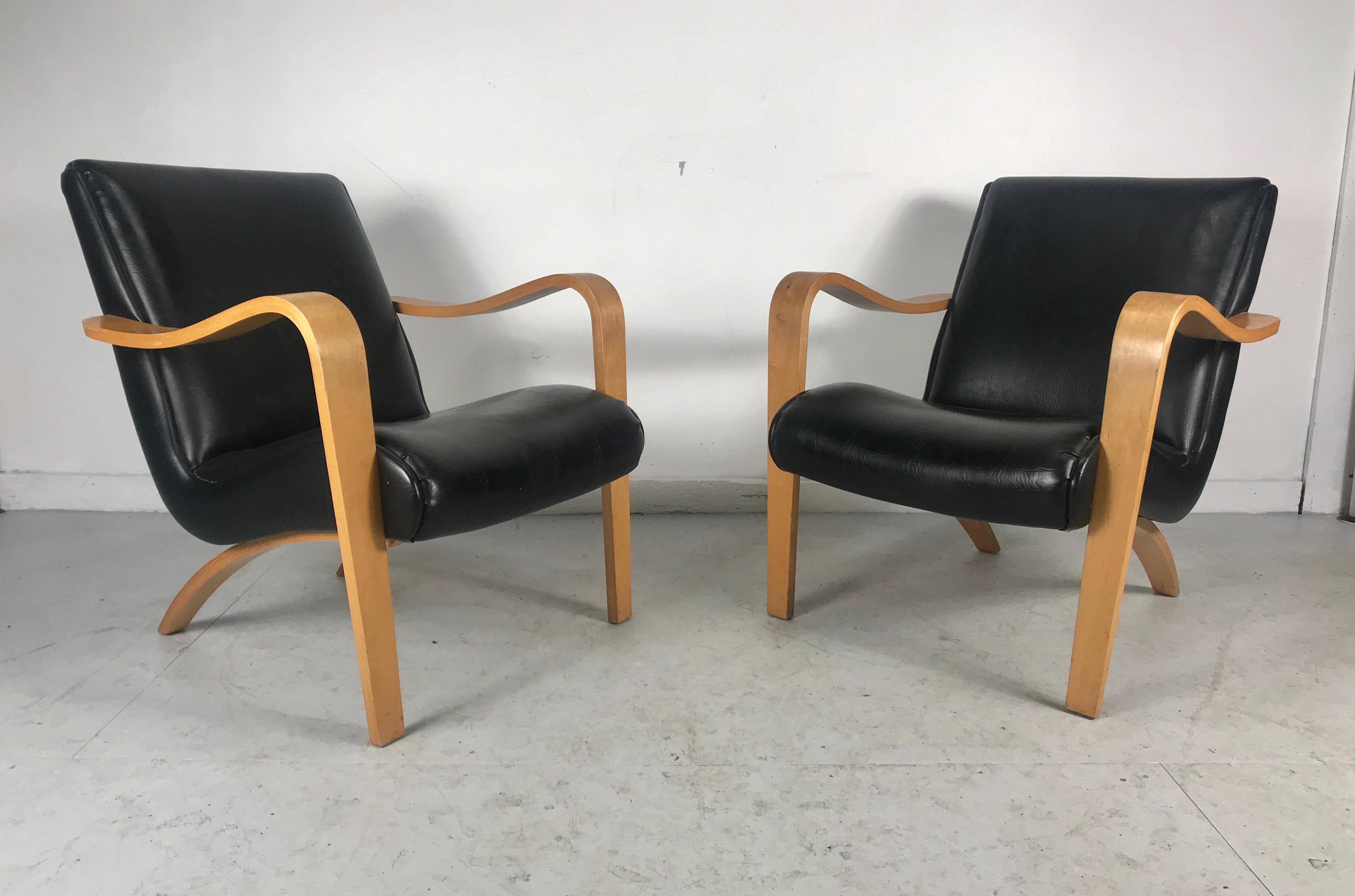 The shapely design of this pair of Thonet lounge chairs features stylish modern design, contrasting black Naugahyde and ergonomic design. Extremely comfortable seats make a unique addition to any modernist, contemporary or eclectic environment, hand