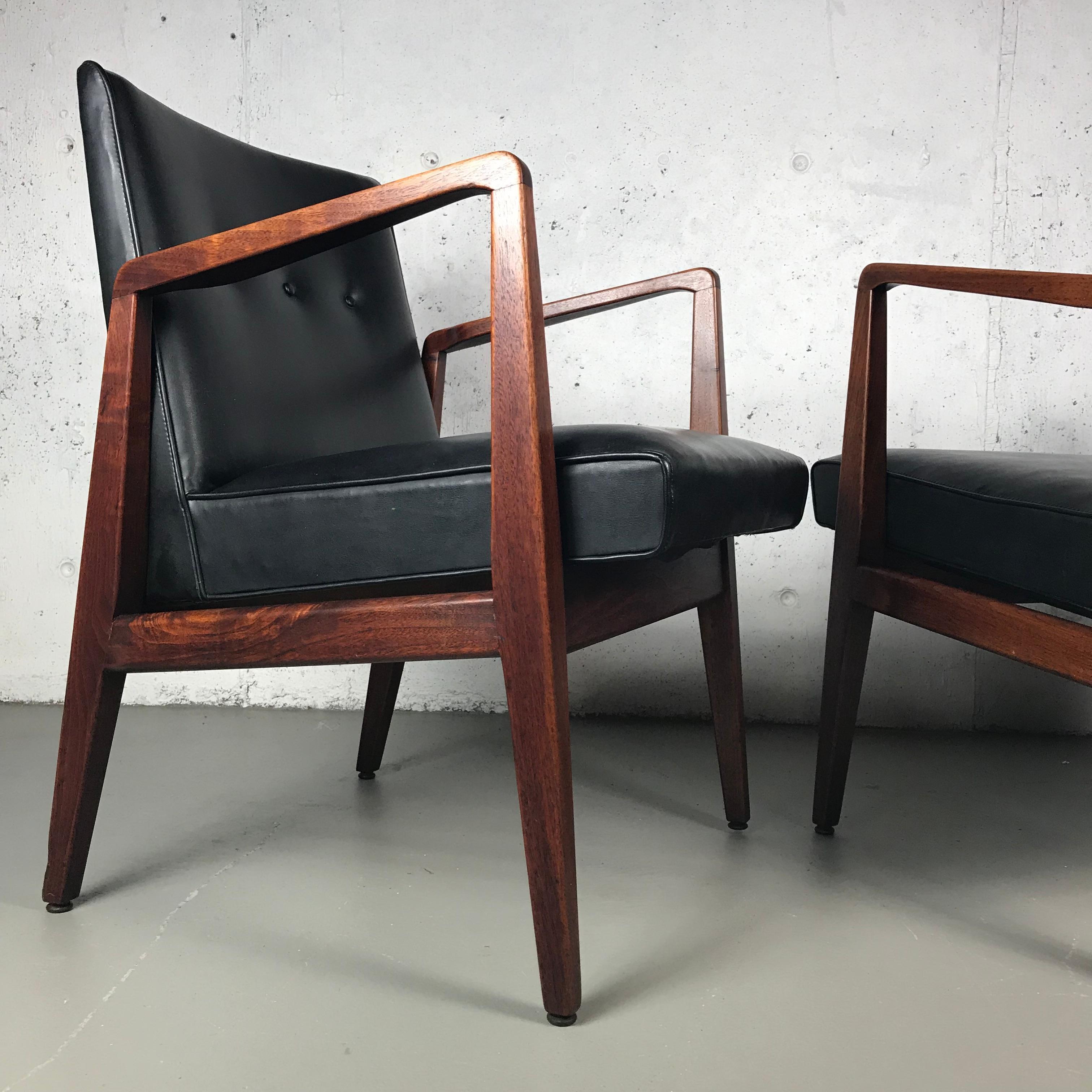 Beautiful pair of occasional or lounge chairs in walnut and black vinyl designed by Jens Risom for Jens Risom Designs. These chairs are in original condition and the walnut has wonderful dark swirling grain. These chairs have patina that present