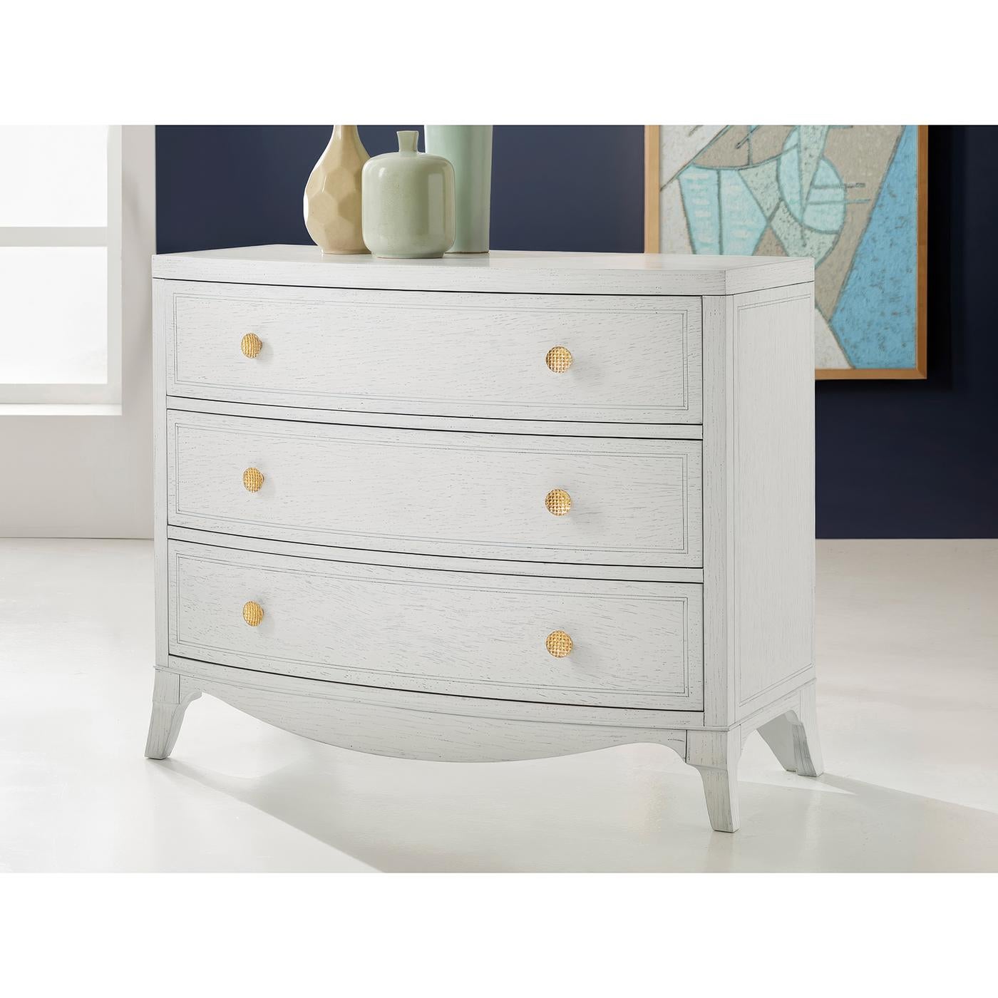 The crisp white finish creates a bright, clean canvas that highlights its architectural elements, while decorative basket weave brass knobs add warmth and sophistication to each of the three soft close drawers. Traditional English Hepplewhite design