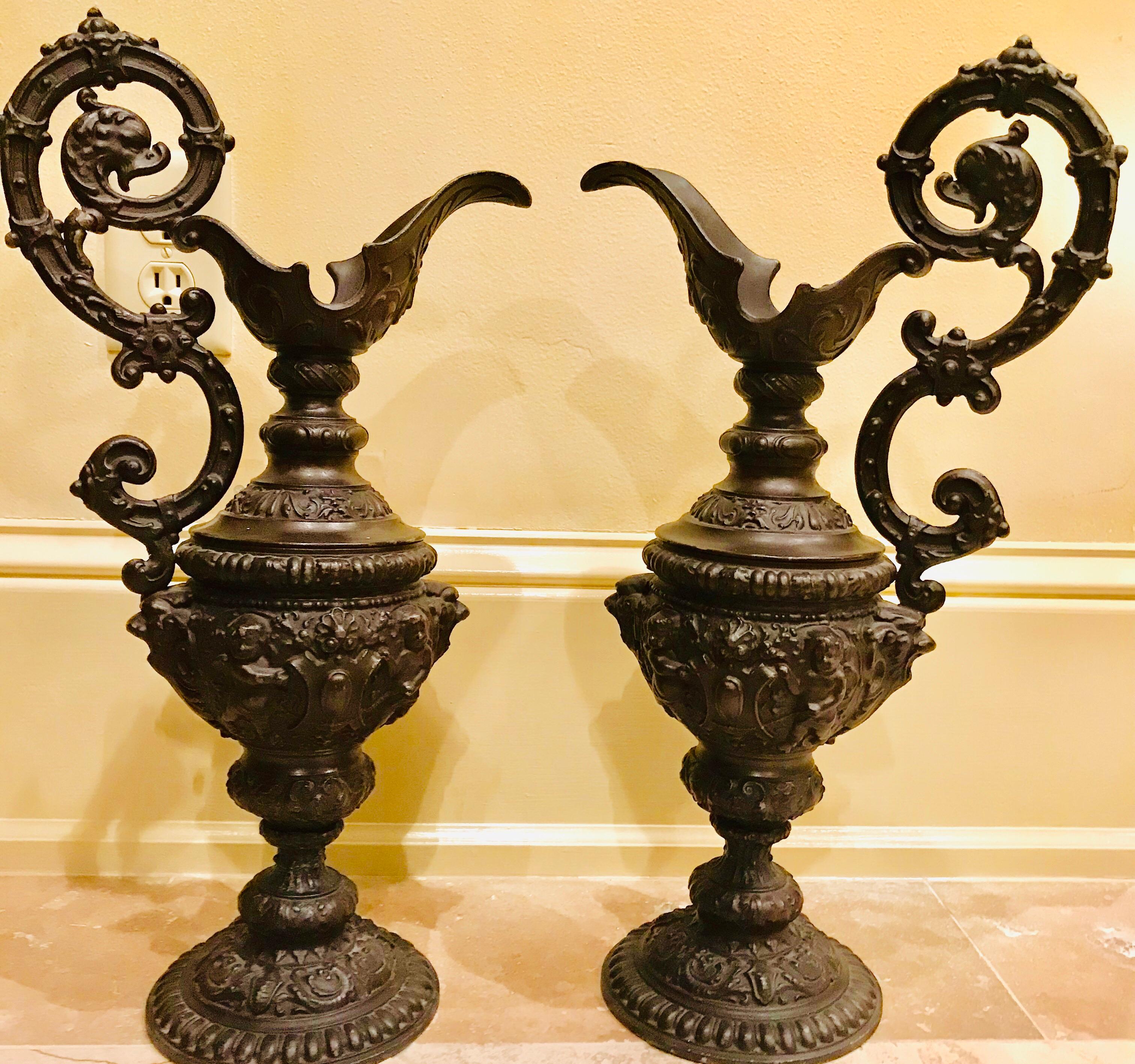 In the Renaissance style, a pair of cast, oiled bronze fountain ewers were originally mounted with piping, pouring perpetually into a basin in a garden in Holland. 

These classical ewers are detailed with cherubs, vines and other classical