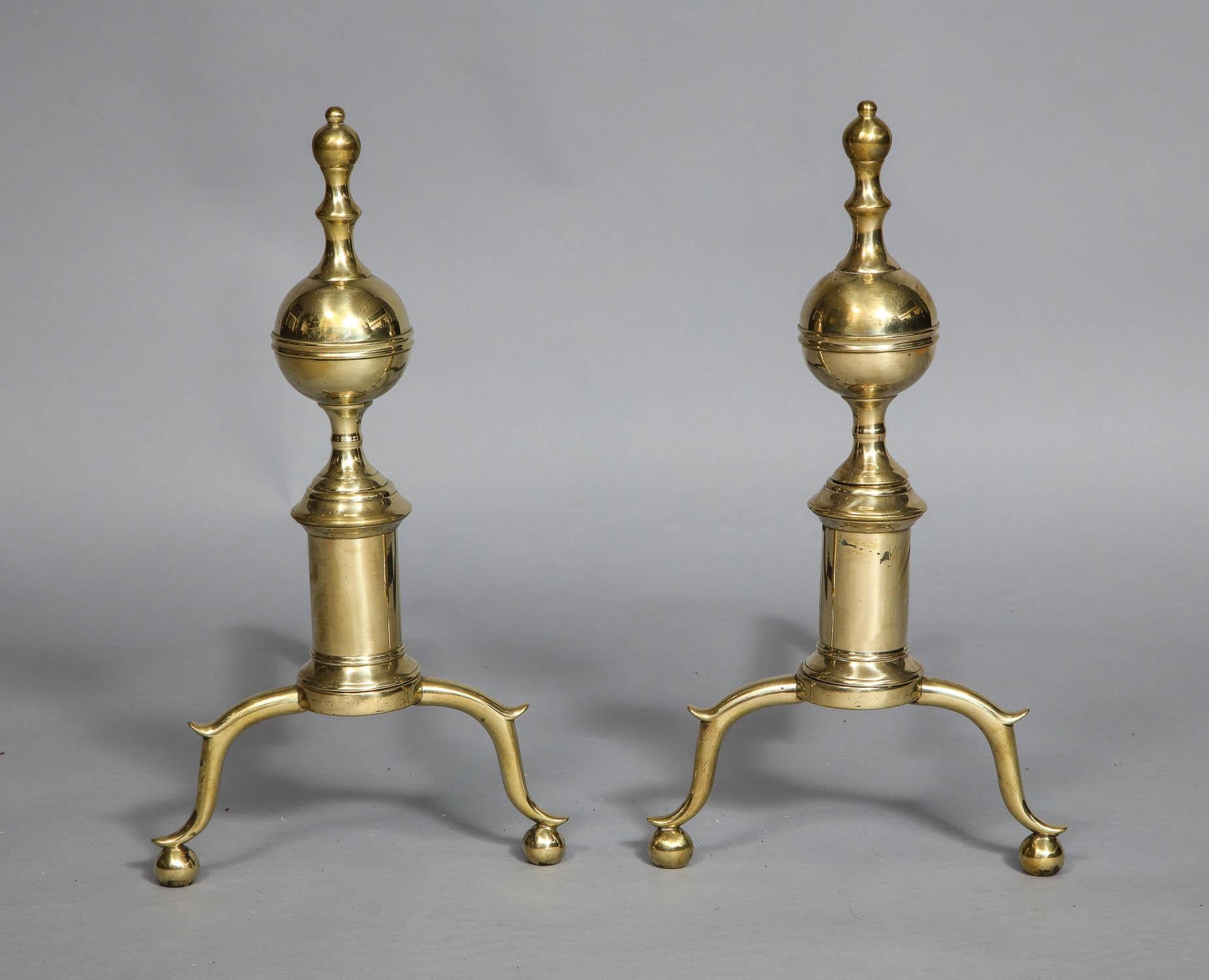 Fine pair of late 18th century brass andirons with turret finials over banded ball tops standing on ring turned collars on cylindrical shafts, standing on ball feet below spurred legs.