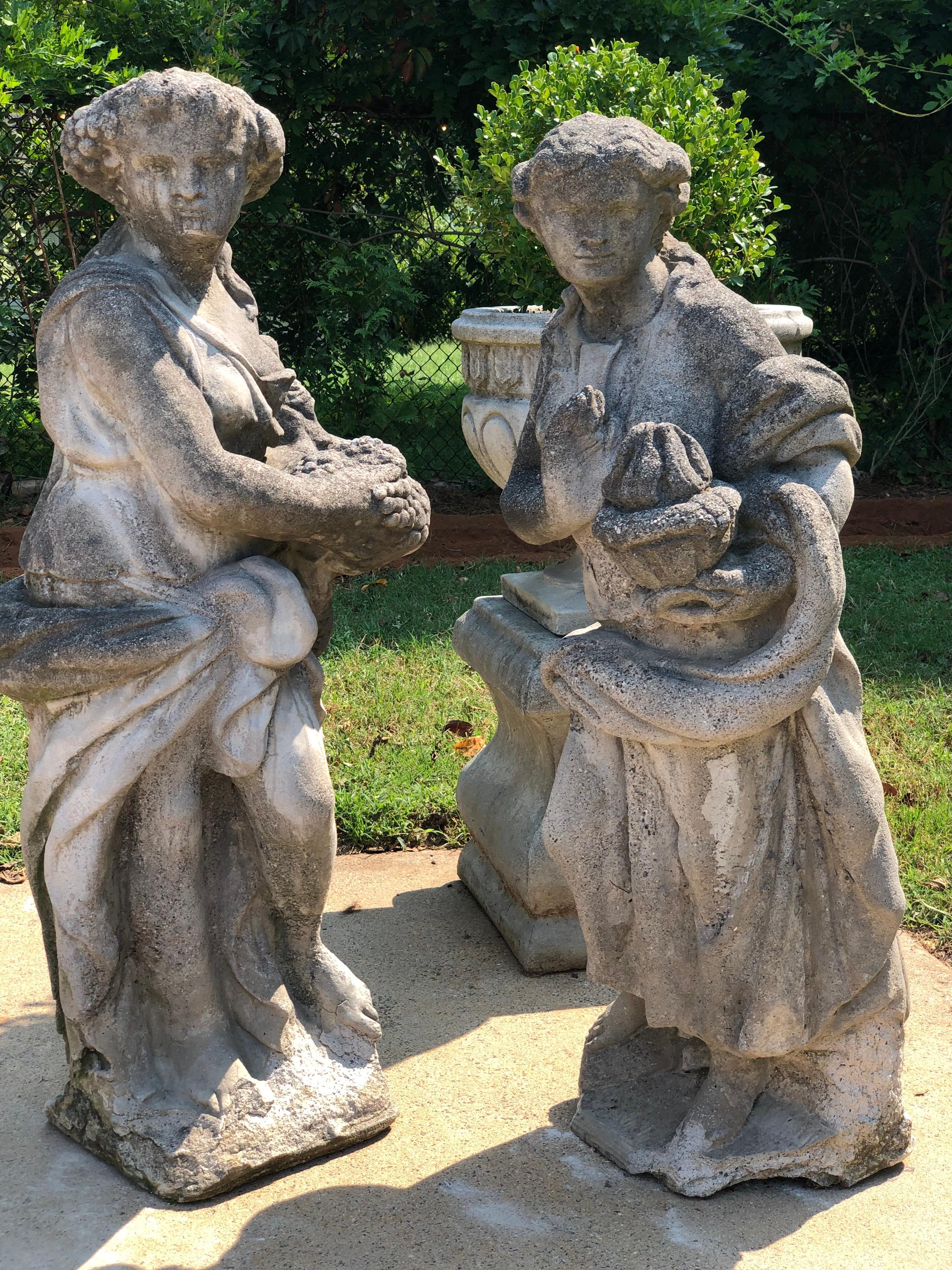 Paire de statues anciennes des quatre saisons. Pierre massive. Femme tenant une flamme et femme tenant des raisins. 
Les quatre saisons sont un ancien motif décoratif et sont devenues particulièrement populaires comme sculptures de jardin. 
Peut
