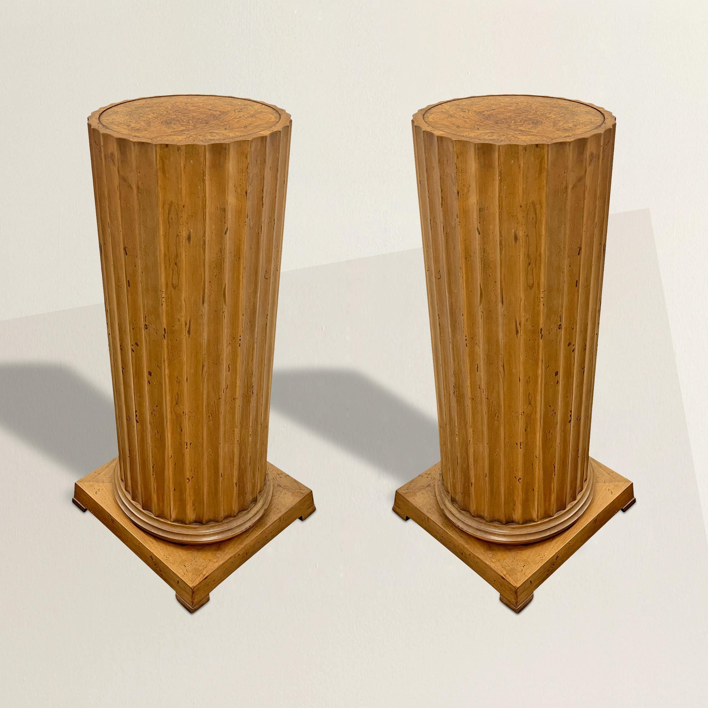 Indulge in the timeless allure of these 20th-century maple pedestals, meticulously crafted to pay homage to the enduring grace of Classical design. With their fluted columns rising from four square feet, and burled maple tops, these pedestals