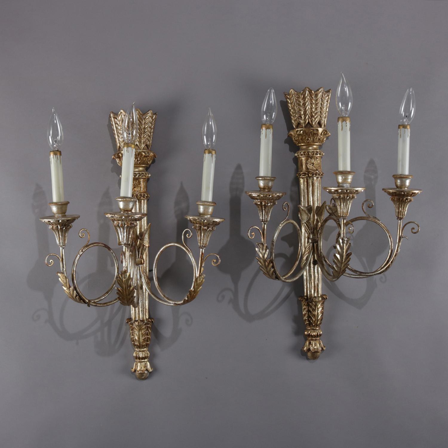 Pair of classical French Empire style electric wall sconces feature gilt finish on torchère form bases and each having three foliate decorated scrolled arms terminating in candle lights with gilt drips, professionally rewired, switch controlled,