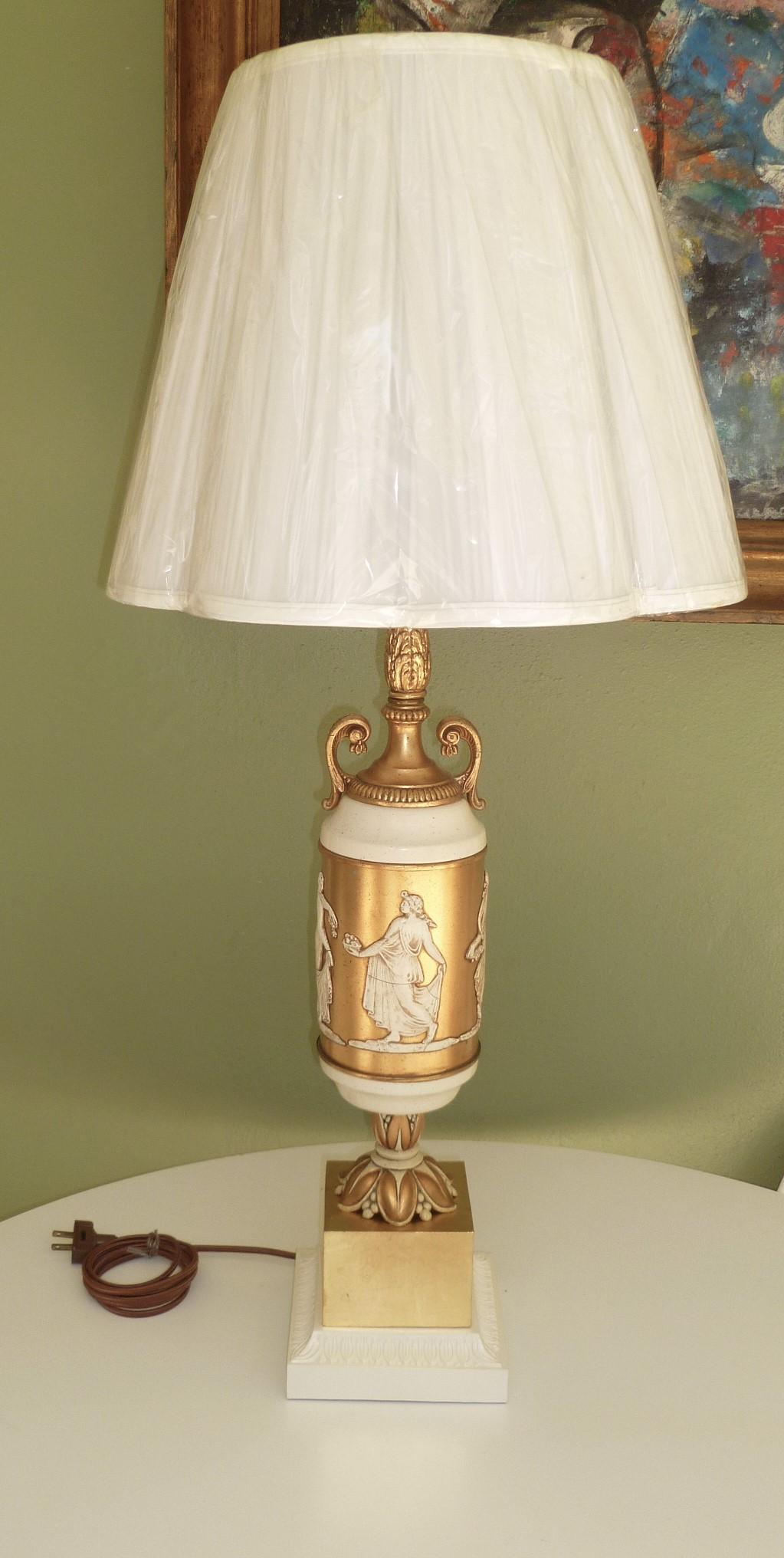 REDUCED FROM $2,500.....A pair of 1940s French parcel-gilt classical urn form table lamps with classical Greek Muses of the arts in relief around the center of the forms. Gilt metal and creamy white patinated, the lamps are rewired with three level