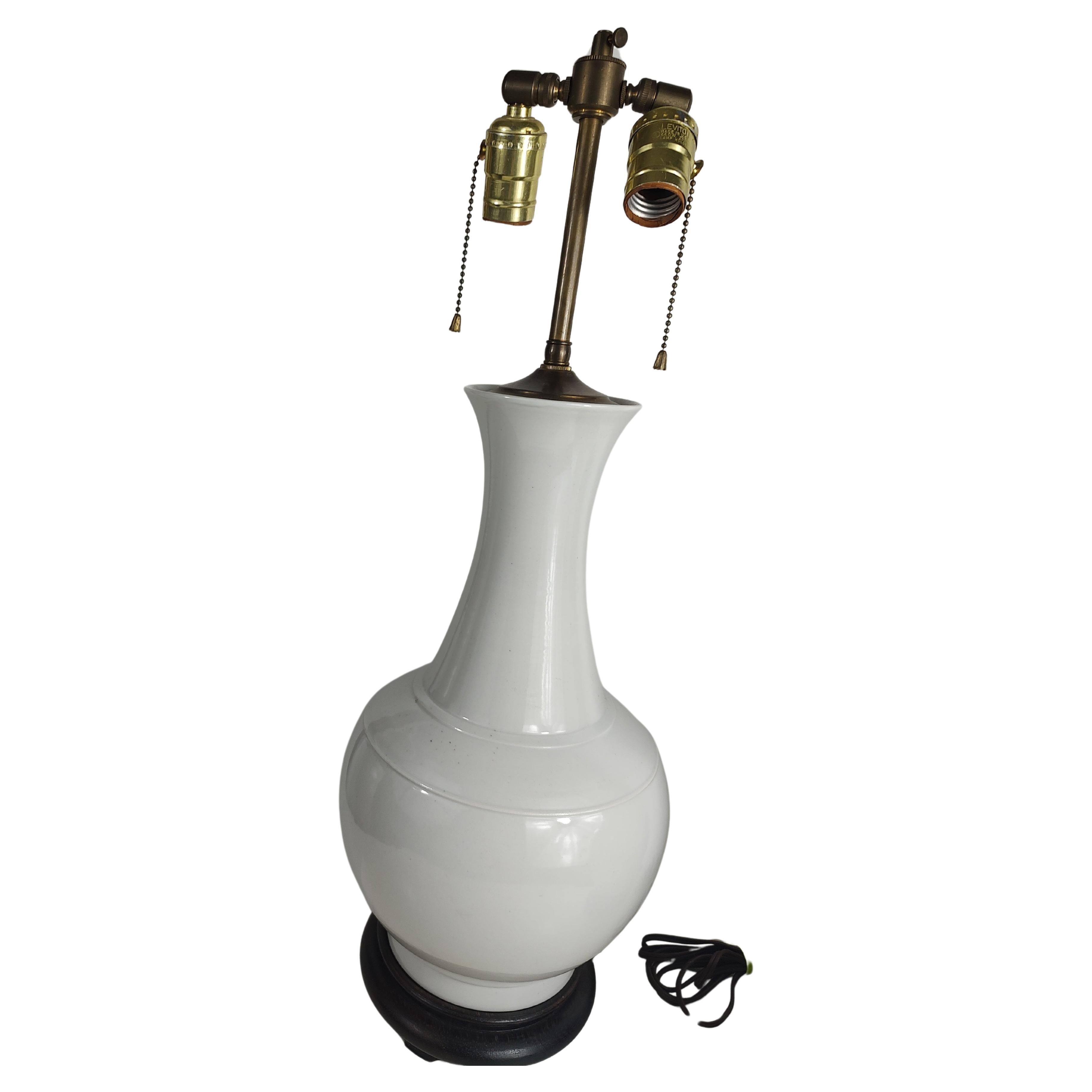 Beautiful pair of white porcelain vases which were turned into lamps some time ago. Simple and elegant pair w is the double sockets. 24 inches to the top of the socket. In excellent vintage condition with minimal wear, no chips or cracks. They sit
