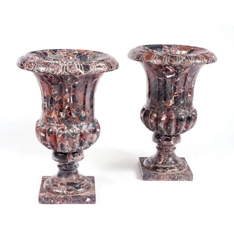 Paire d'urnes en marbre de forme classique avec une tige cannelée et une cosse nervurée sur une base carrée.