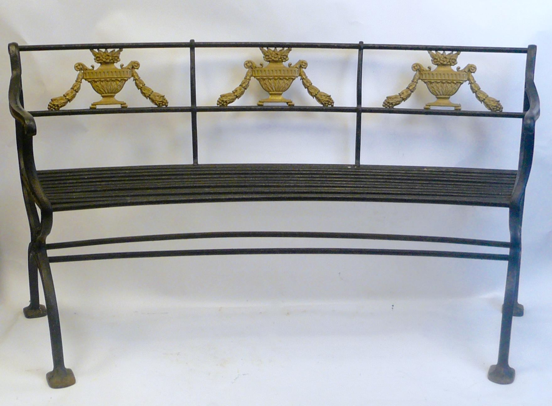 This handsome pair of slightly bow shaped iron garden benches are signed W. A. Snow, Boston. The backs feature neoclassical style lidded urns and swags.