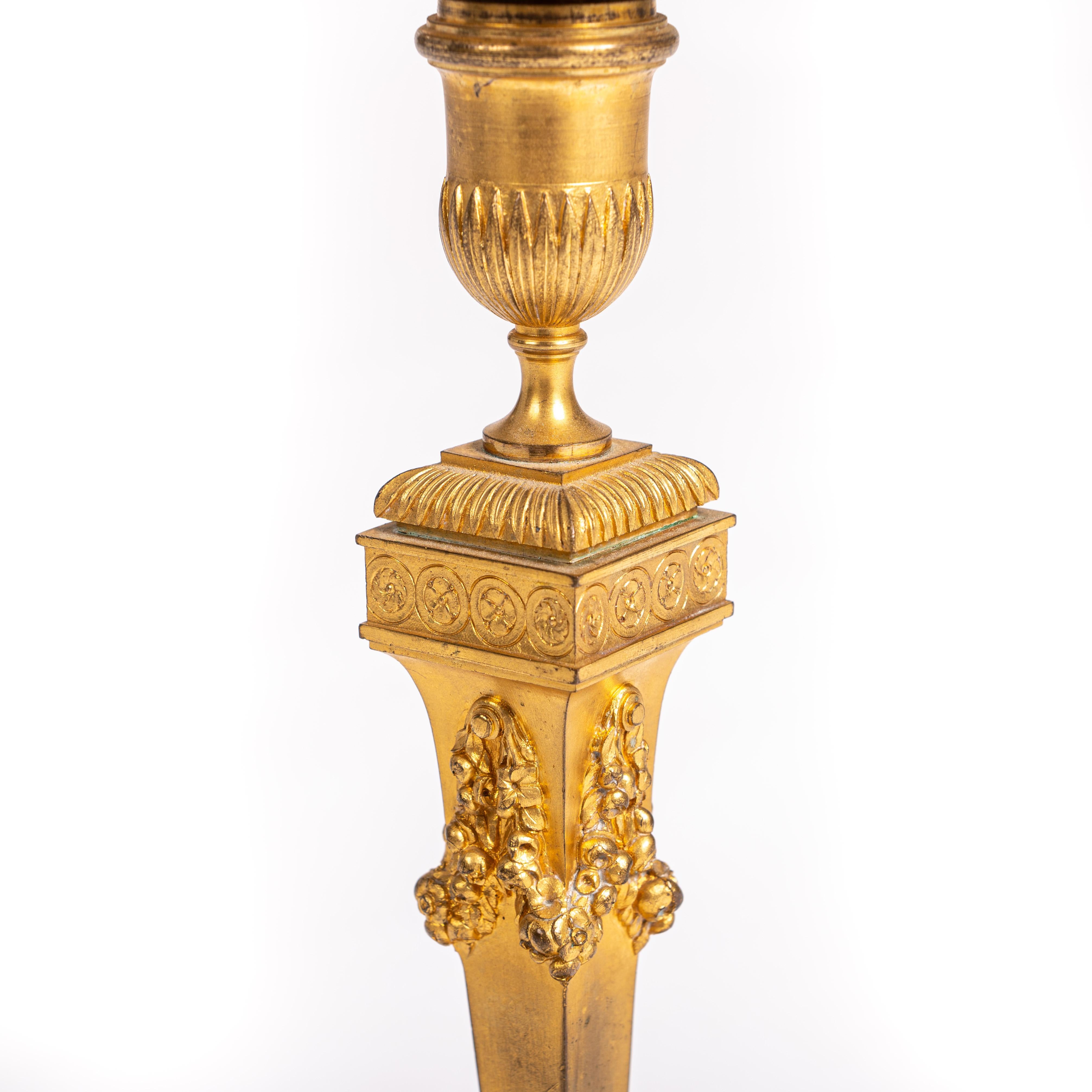 Pair of strict classicistical fire gilded candlesticks France 1840, signed Barbedienne.

Strict classicist design with square base, flowers and leaf ornaments in different finish. Decorated and smooth elements in alternation create otically balanced