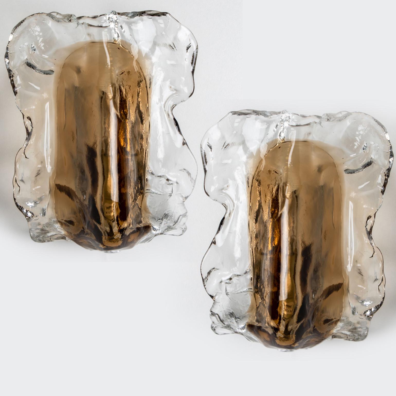 Pair of high end wall sconces made of hand blown clear and brown (smoked) Murano glass on a chrome backplate. Designed and manufactured by J.T. Kalmar, Austria in the 1960s. Unique, because of their unusual shape. Minimalistic design executed with a