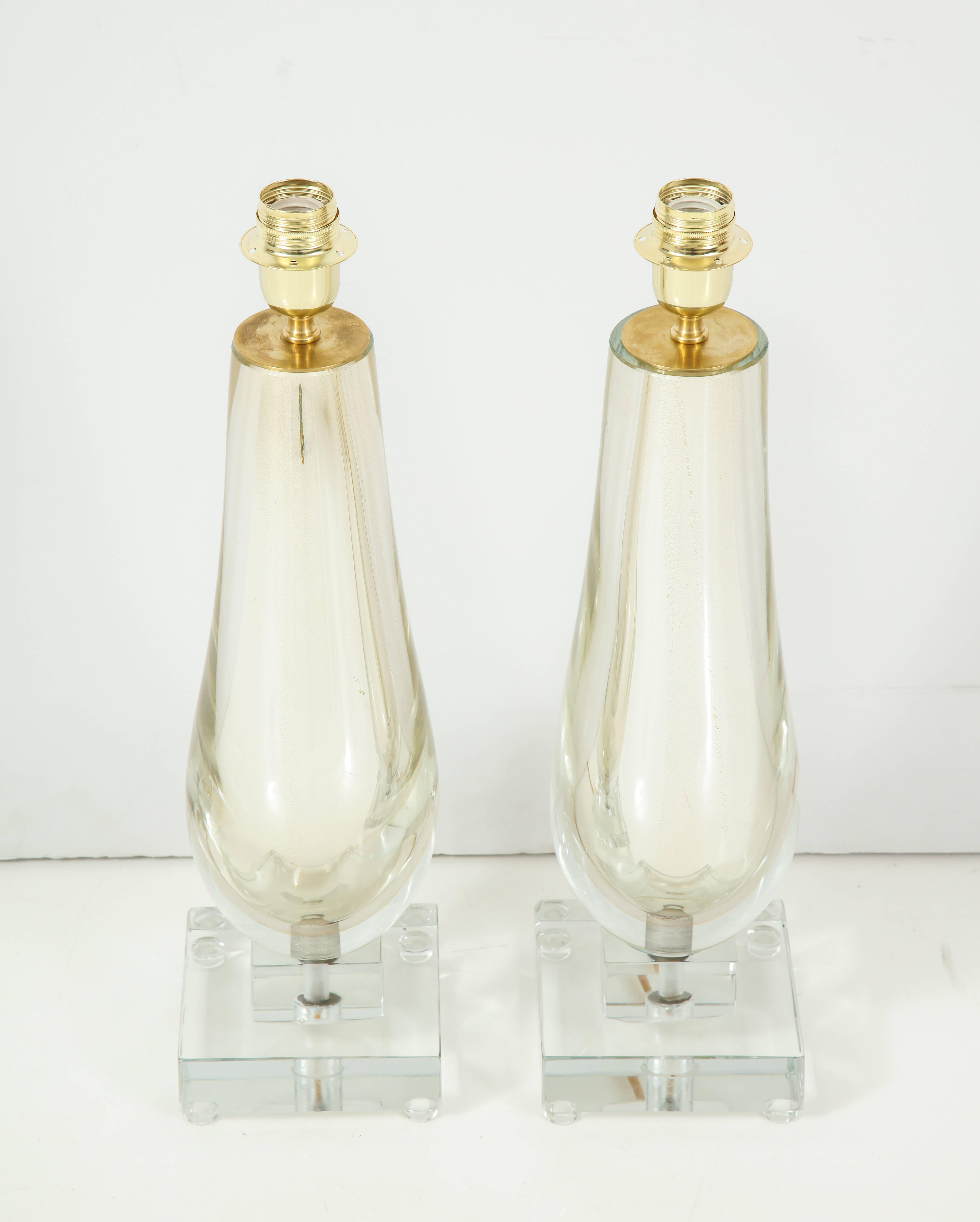 This pair of clear and gold mirrored Murano glass lamps is absolutely stunning! Comprised of hand blown clear glass layered over shimmering gold mercury glass to create a mirrored effect. The jeweled base sits atop two solid Murano clear glass