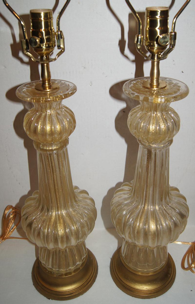 Pair of 1940s Murano clear and gold Murano table lamps with gilt bases.

Measurements:
Height of body: 18
