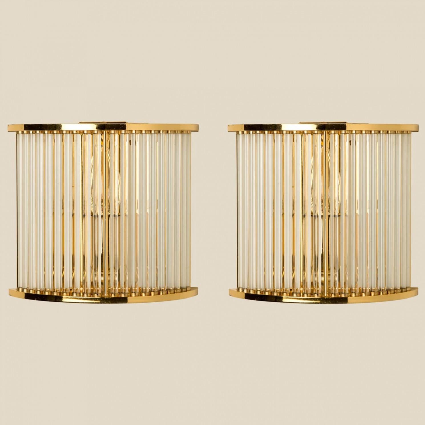 Beautiful halfround ridged glass wall sconces with brass details. Illuminates beautifully. High-end pieces.

Cleaned and well-wired, in full working order and ready to use. The glass tubes are all original and in very good condition.

Please note