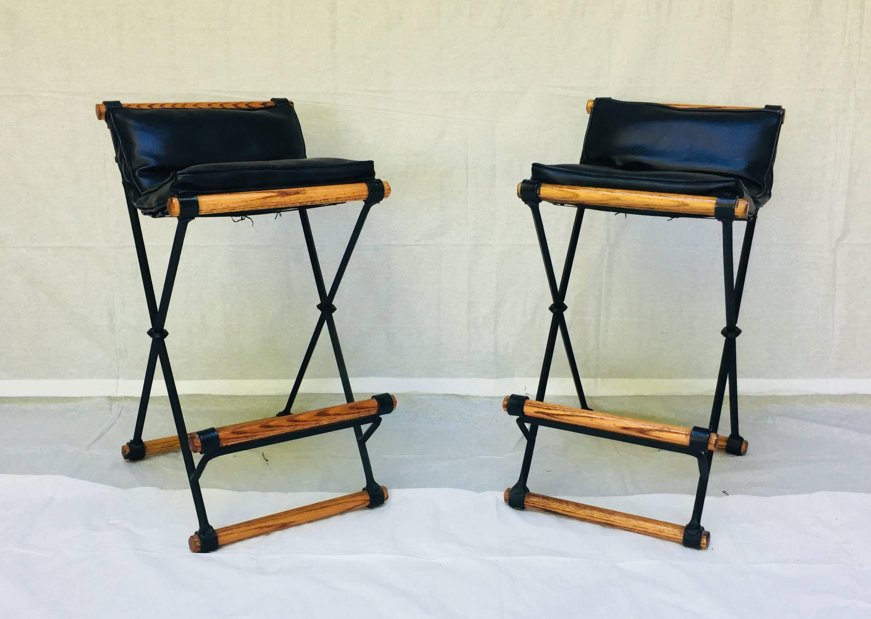 One pair of Cleo Baldon wrought iron and oak bar stools manufactured by her company Terra in the 1960s.
The frames and the vintage black vinyl cushions are in excellent condition .


 