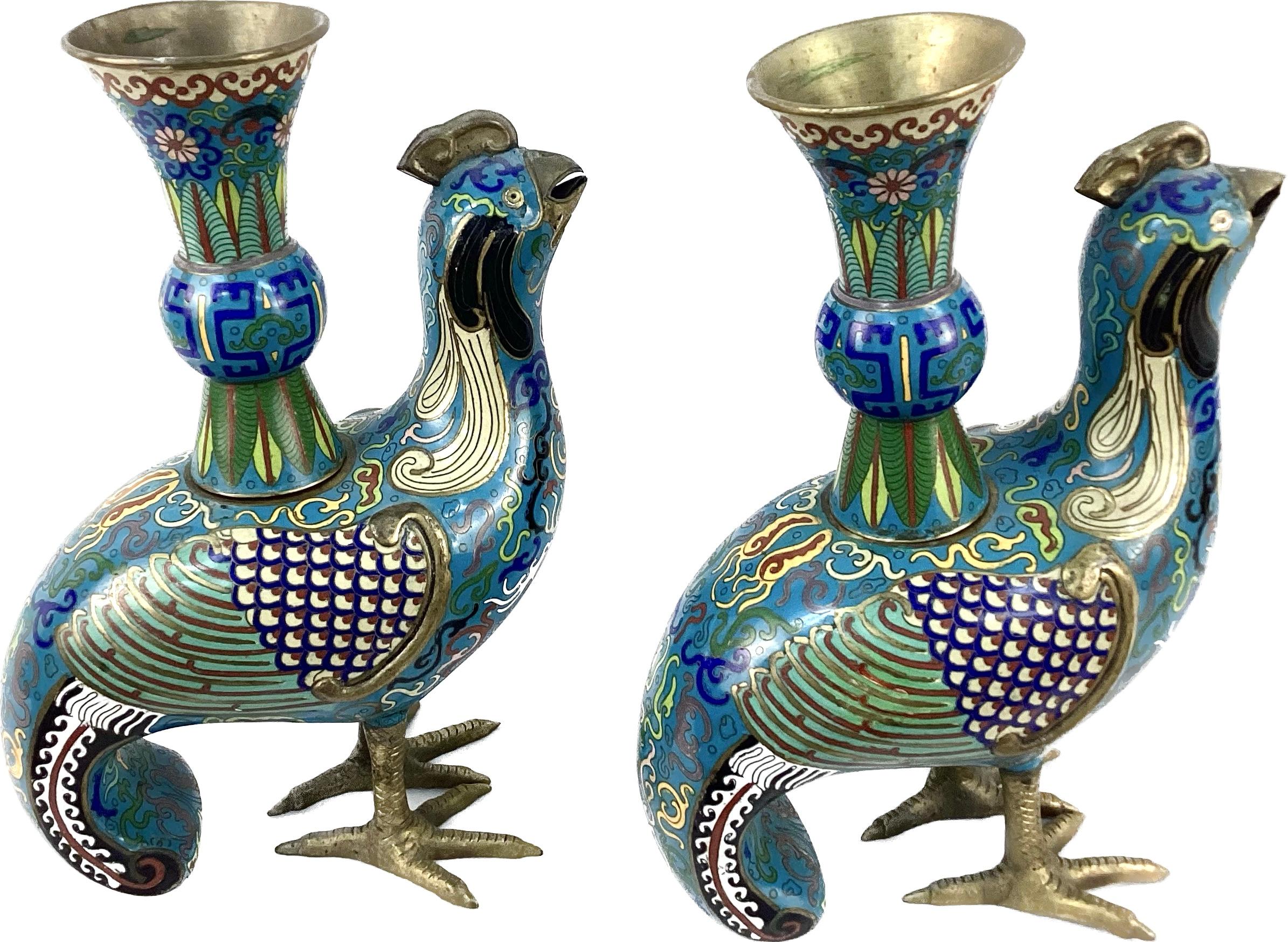 Pair of matching polychrome Archaic style Cloisonne birds each featuring an archaic design and decorated in blue, green and multi colors. Each bird has fan-shaped feathers and scrolling designs throughout down to beautifully curved tails. Each