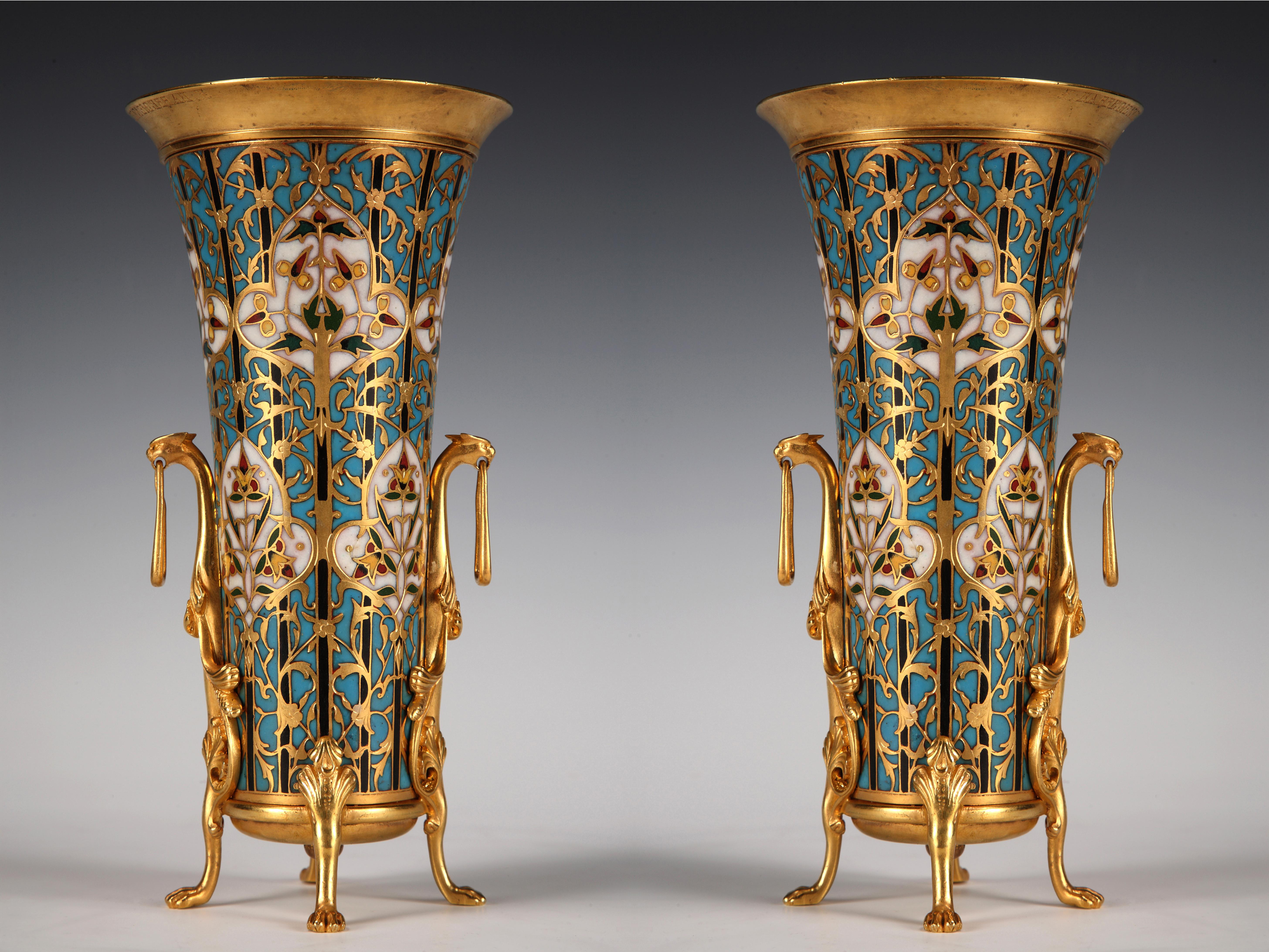 Signé F. Barbedienne

Paire de vases en forme de trompette en bronze doré et émail cloisonné polychrome, ornés de motifs floraux stylisés. Repose sur quatre pieds à tête de lion, avec des poignées mobiles.

Né en 1810, Ferdinand Barbedienne a