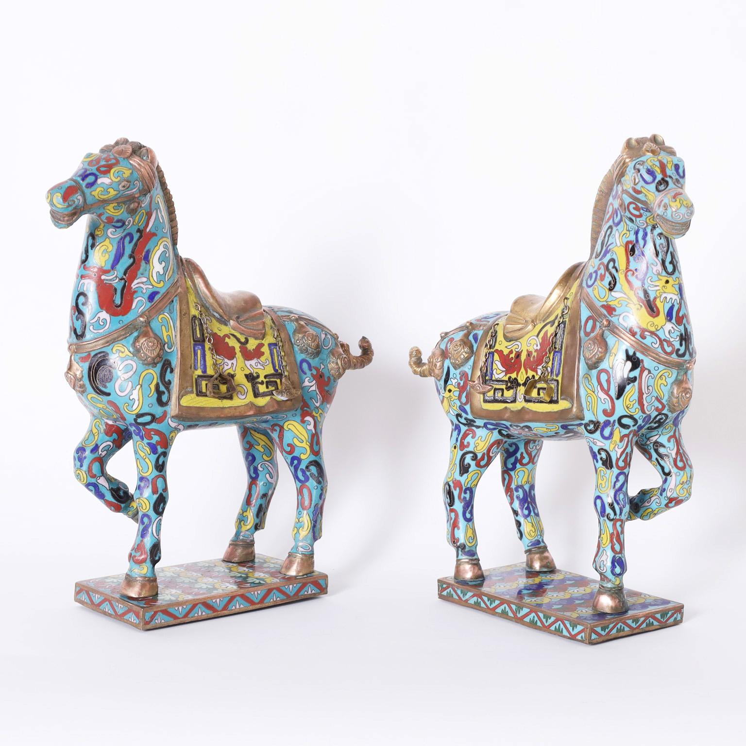 Vintage pair of Chinese cloisonné horses with a Tang dynasty form decorated with colorful symbolic references on an alluring blue background.