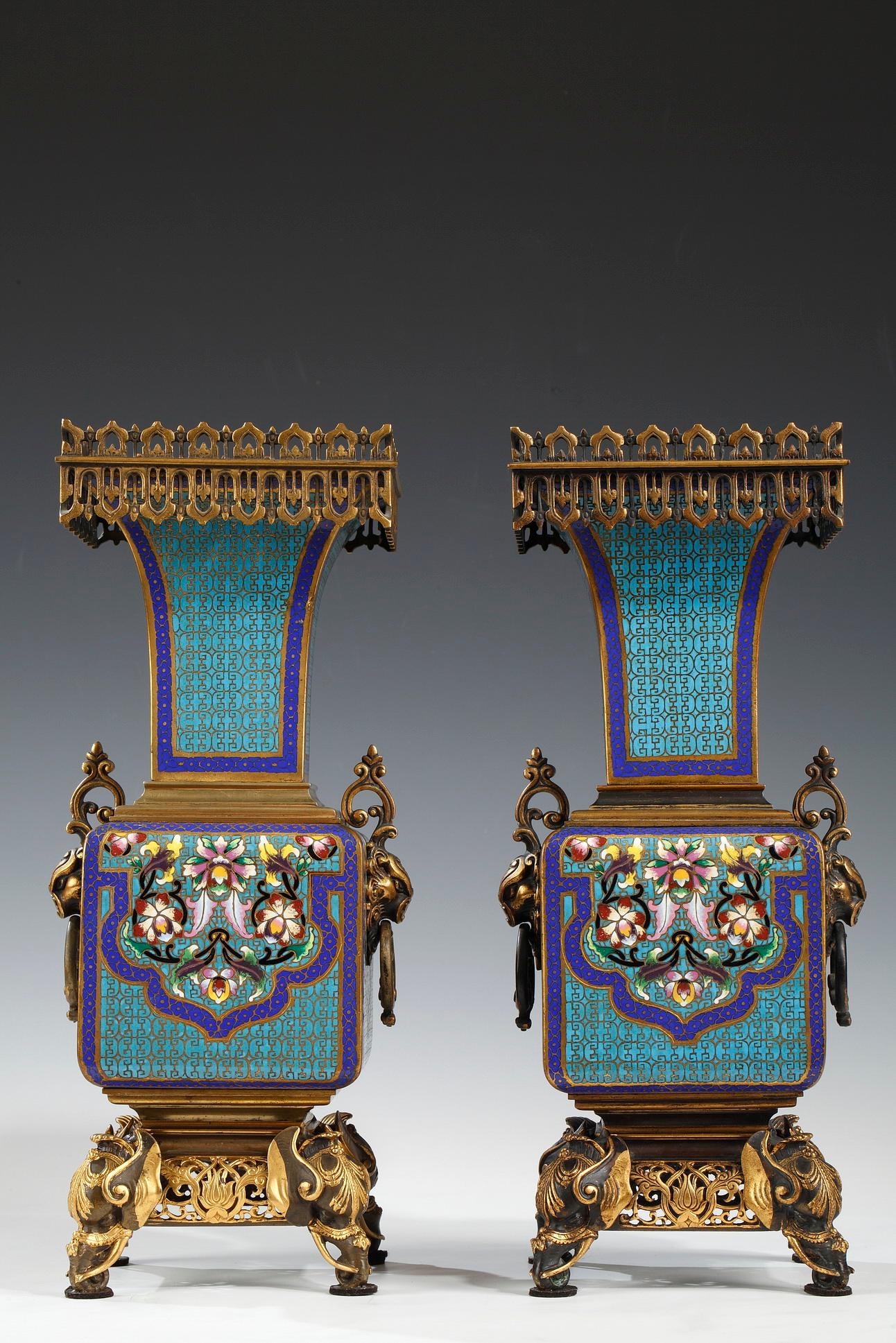 Pair of cloisonné enamel square vases attributed to A. Giroux, with flared neck decorated on the belly with flowering lambrequins with oriental patterns on a blue and golden geometric. The mount in patinated and gilded bronze is composed of an