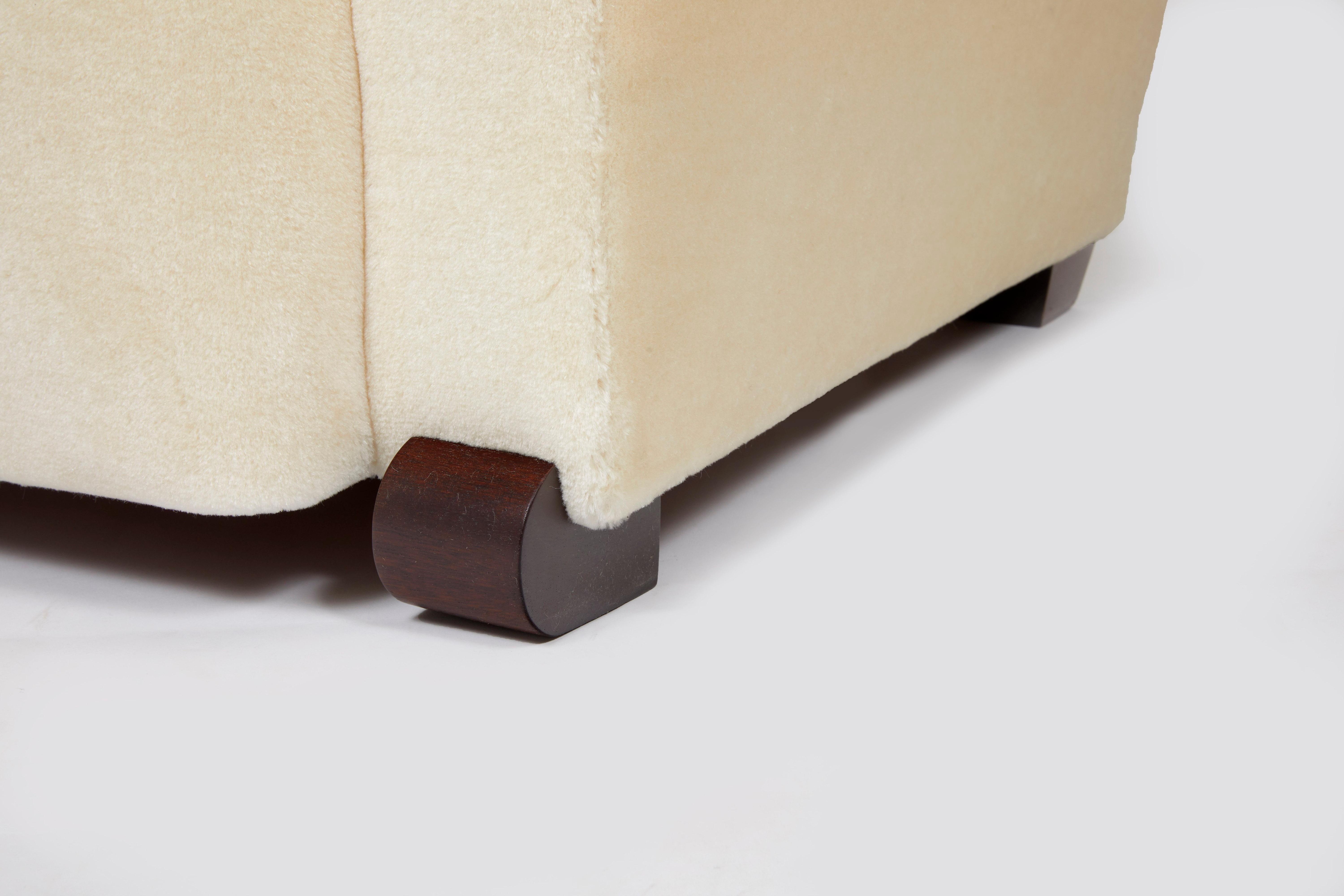Abgerundete Beine aus gebeiztem Holz, bezogen mit cremefarbenem Mohair.
