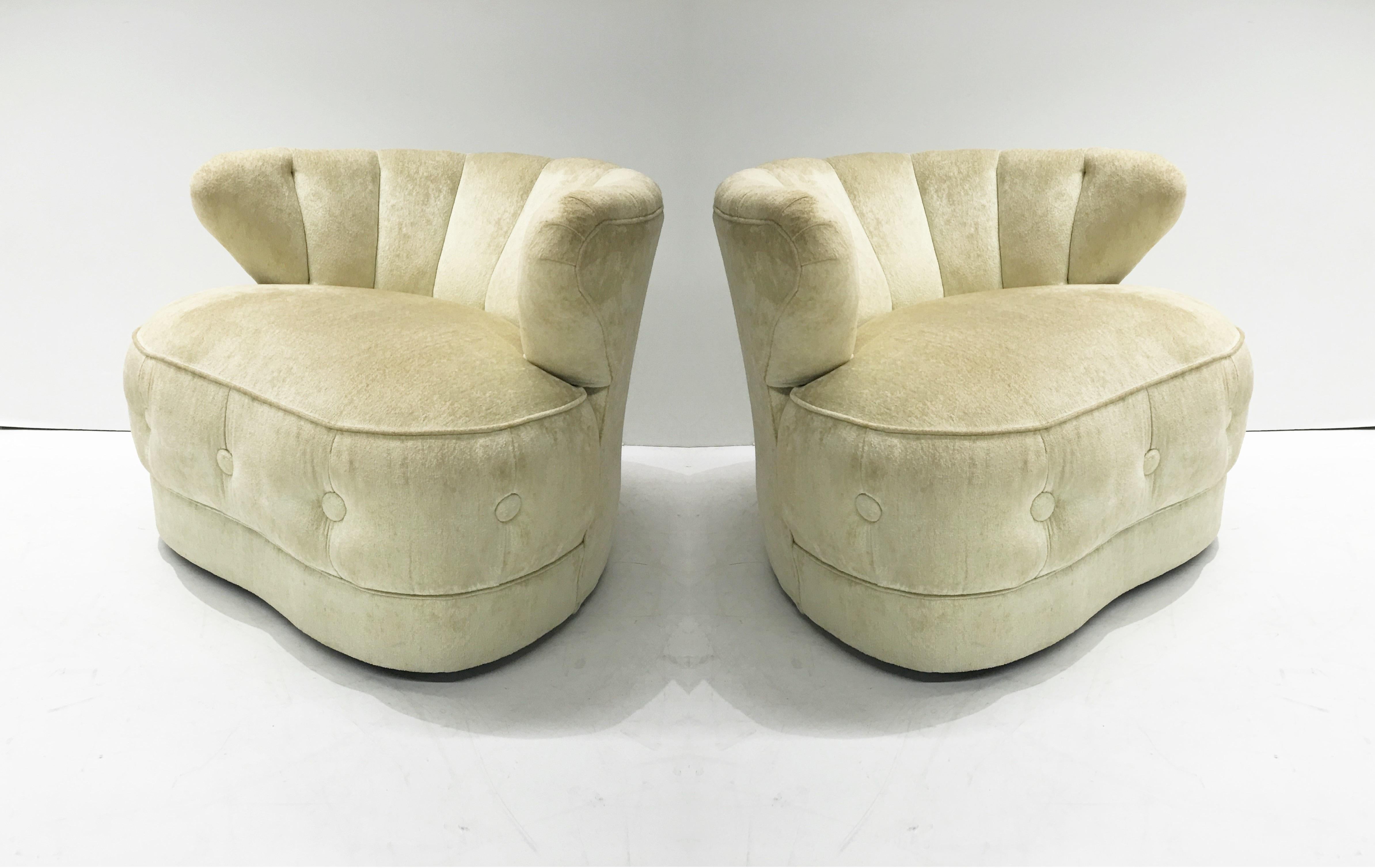 These glamorous and elegant chairs by James Mont, circa 1950. Each chair sits low and has a channeled barrel back that curves around, a thick cushioned seat and ebonized feet. Original cream colored velvet upholstery can be used as is or