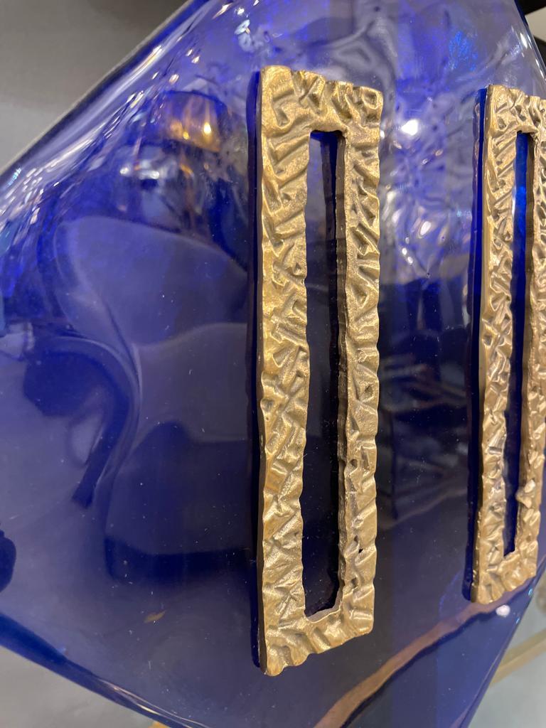 This stunning pair of table lamps consists in a square cobalt blue Murano glass central piece brass decorations. The frame, in brass, is mounted on a glass base.