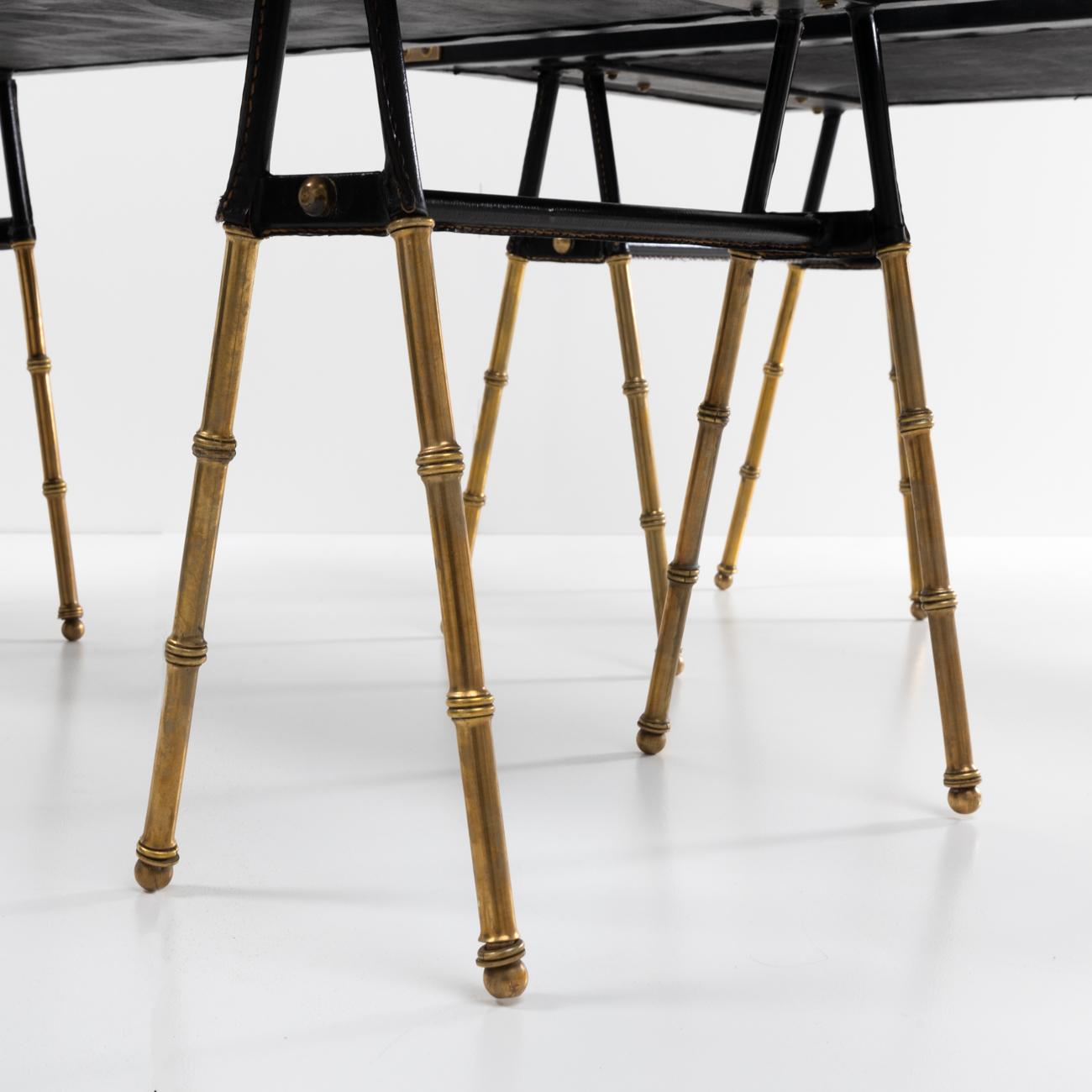 Nice pair of cocktail tables or end tables in solid copper with faux bamboo decor, the upper part covered with saddle stitching leather. 
The legs are surmounted by a leather tabletop and decorated with accessories. 
The tables are entirely made