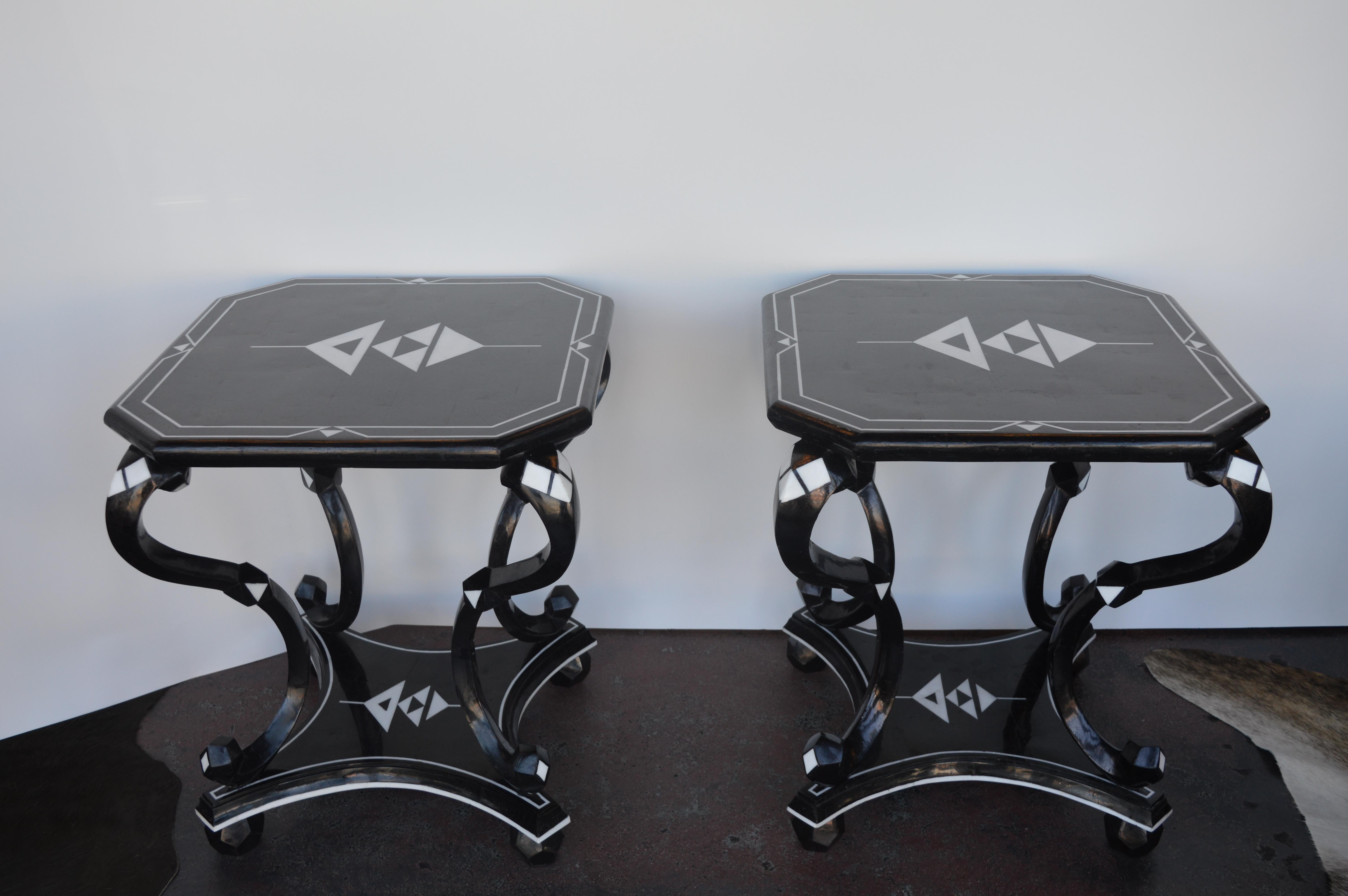 Two white and black side tables made of coconut shells. Triangle design on the top and the base of the side tables.