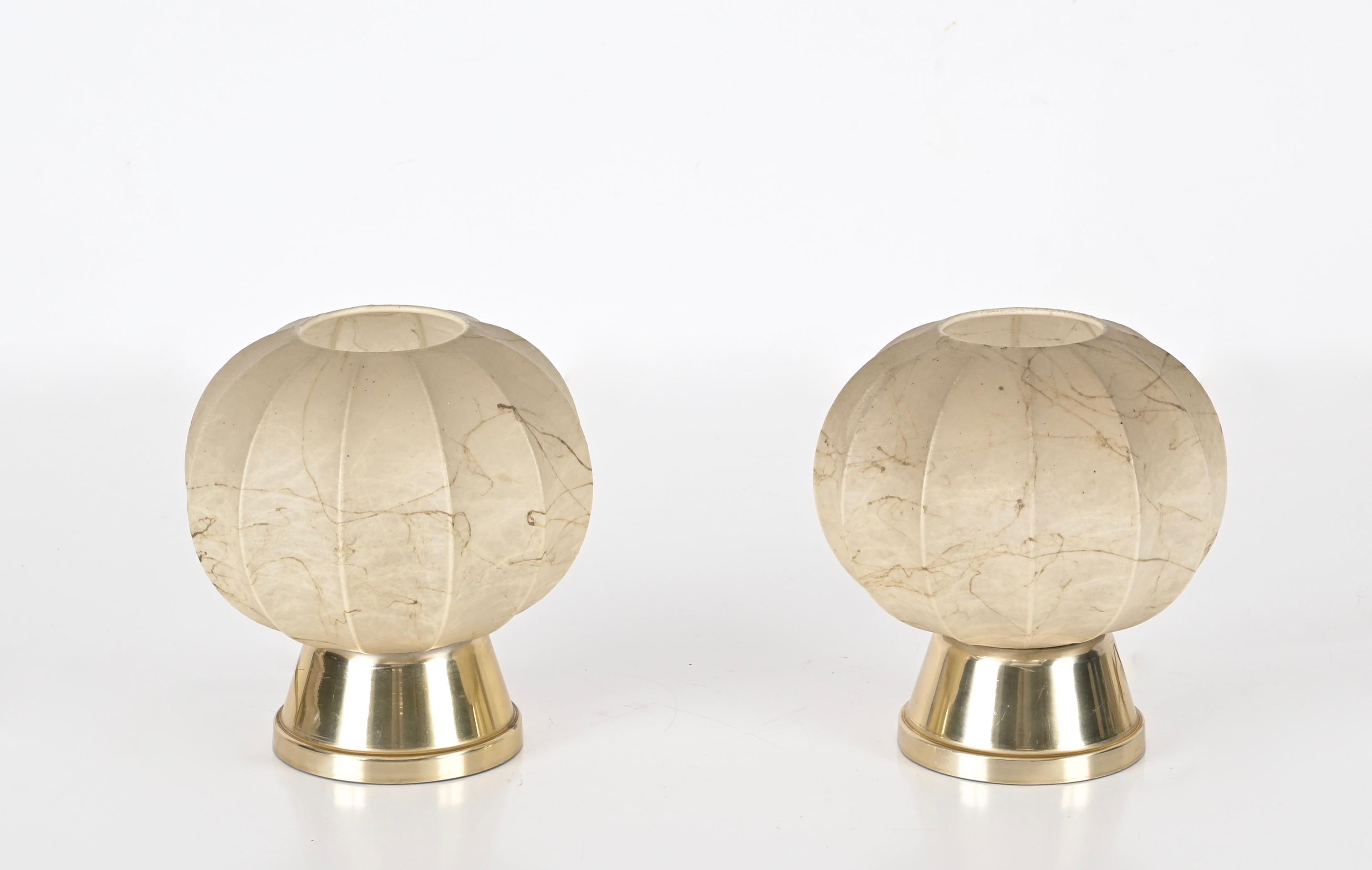 Stunning pair of cocoon table lamps with gilt metal base. These rare table lamps were designed by Achille Castiglioni in Italy during the 1960s.

This gorgeous pair of table lamps feature a gold metal base with a beige 