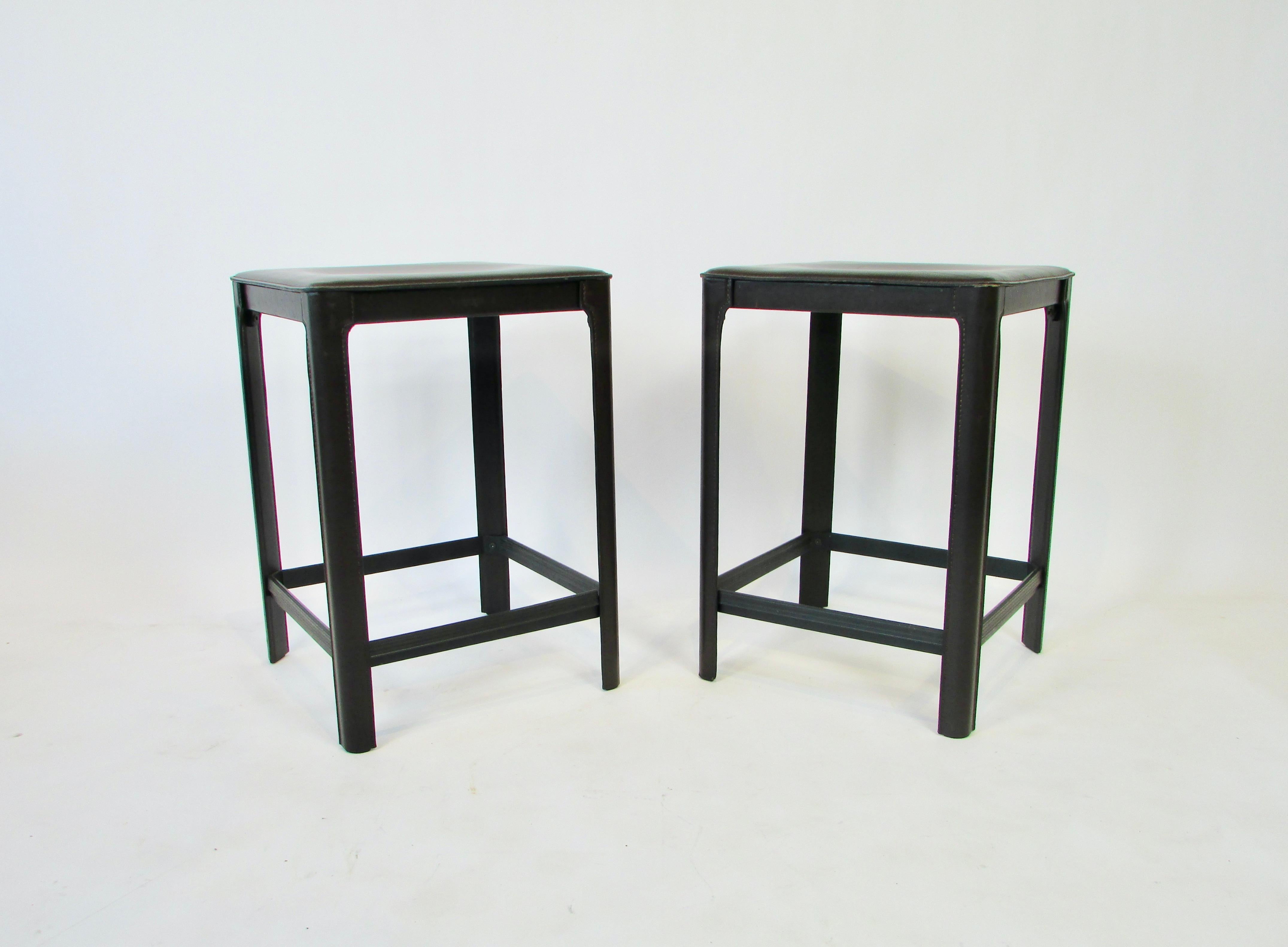 Clean original pair of Matteo Grassi stools. Postmodern 1970s stools in coffee tone leather The stools are completely covered in leather, stitched and molded on to the metal frame. Very nice condition.