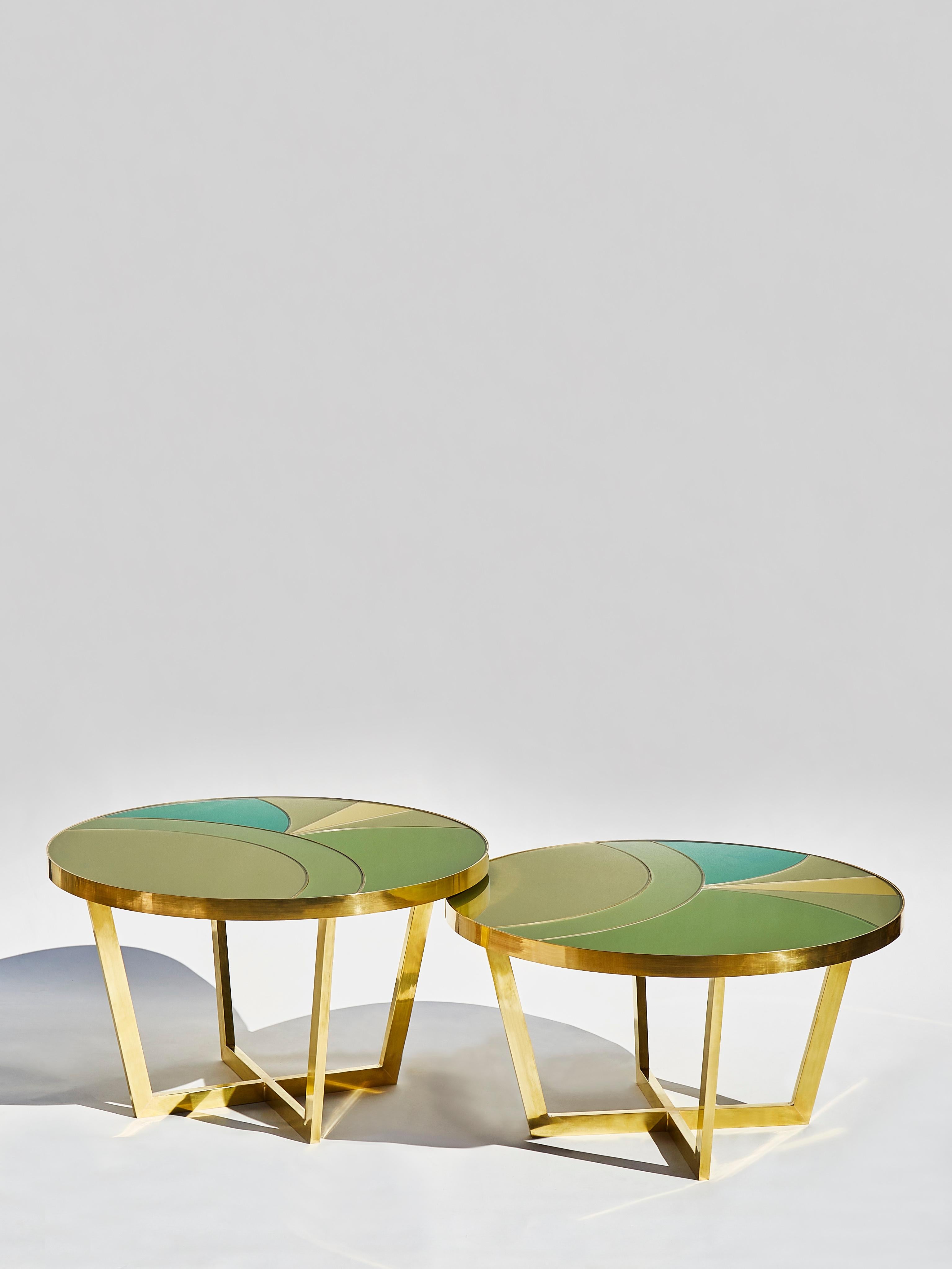 Pair of coffee tables in brass with a top made of Marquetry of tainted mirrors with brass inlays.
Each coffee table has a different height in order to slide one under the other.
Creation by Studio Glustin.

Dimensions:
Diameter 85 x height 52