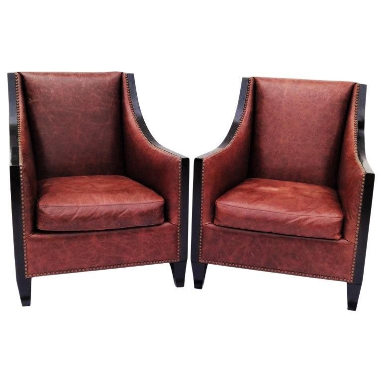 Fantastic pair of Deco style club/lounge armchairs. Original upholstery in a rich cognac leather finished with metal studding and newly lacquered black frames.