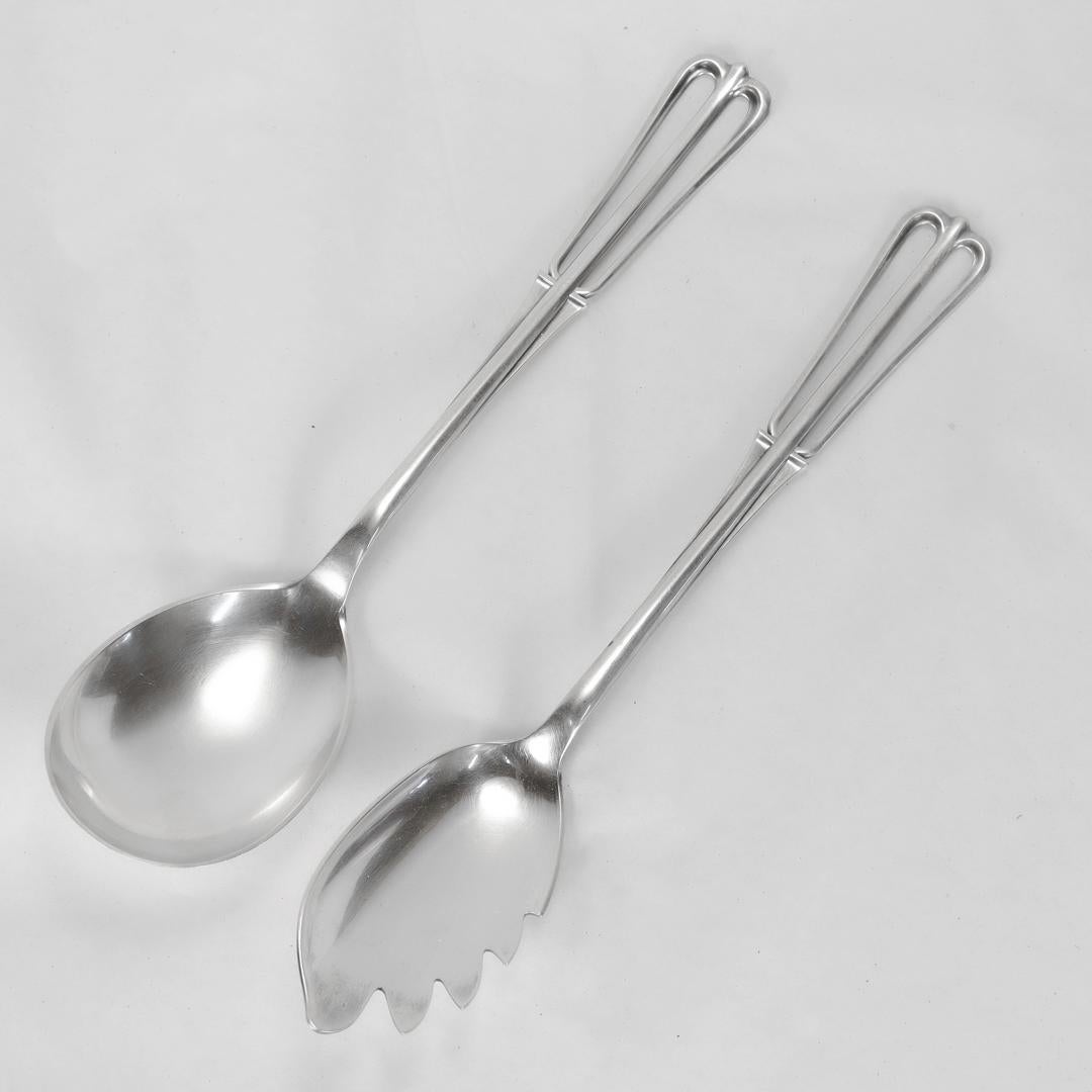 A fine Danish Mid-Century Modern salad serving set.

In sterling silver.

By Cohr. 

Each with a Modernist stylized crown shaped handle.

(To our knowledge the pattern is unnamed.)

In general, the silversmiths at Cohr had a large impact on European