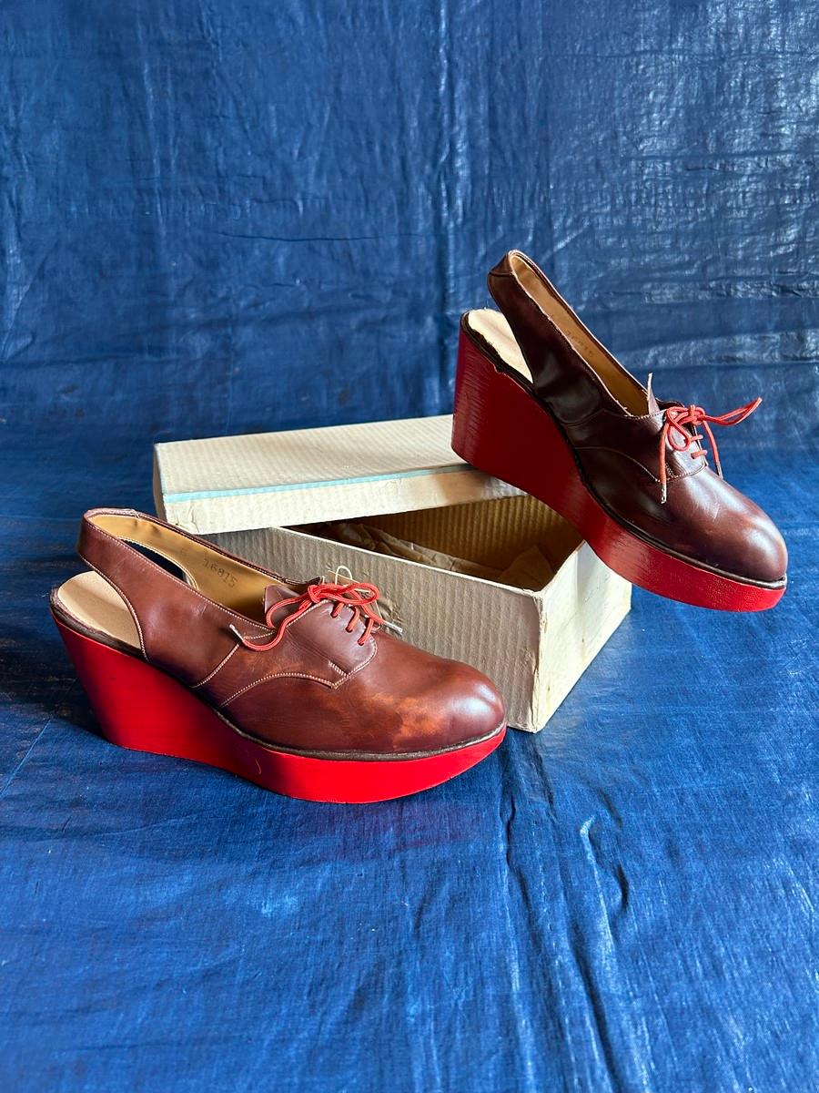 Circa 1940/1950
France

Rare pair of collectible shoes in mint condition with red painted wooden wedge heels, dating from the 1940s. Original hazelnut brown gloss leather upper with red laces, with shop label. Cream vinyl lining and sole with