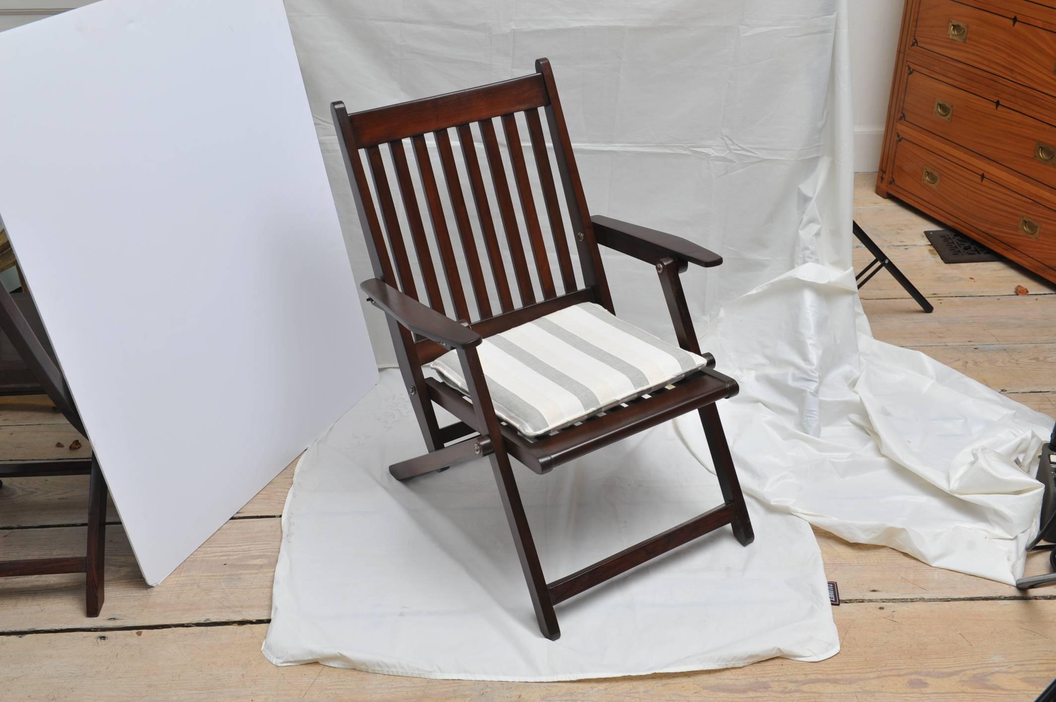 Pair of early-mid 1900s rosewood, folding steamer chairs. Used on the decks of British steamer ships traveling to and from the Colonies. Custom-made seat cushions in a soft white and grey stripe, zippered. A subtle recline making them comfortable